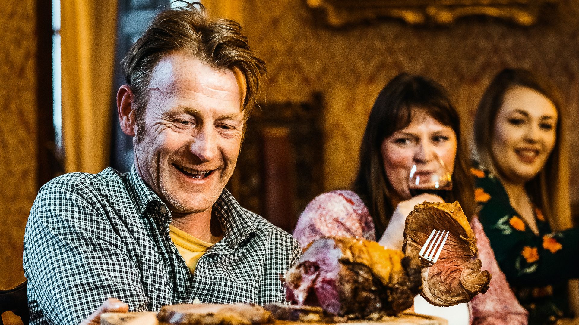 man in blue and white checkered button up shirt holding bread