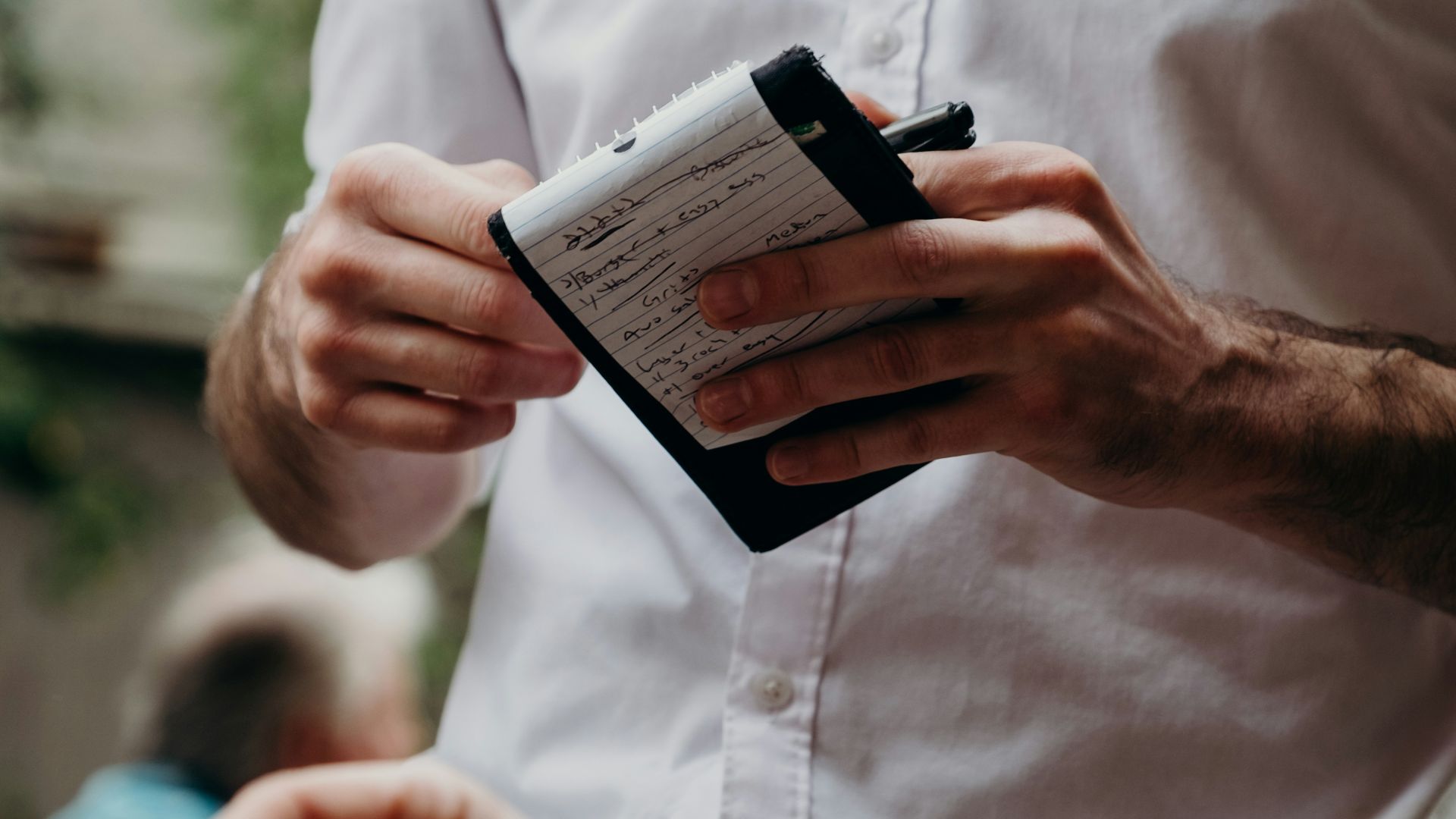 man in white button up shirt holding black and white box