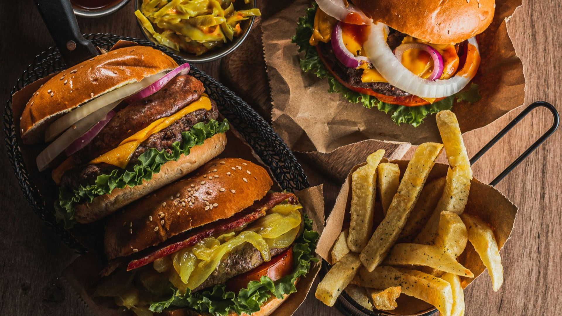 Burgers and fries with beer on wooden table