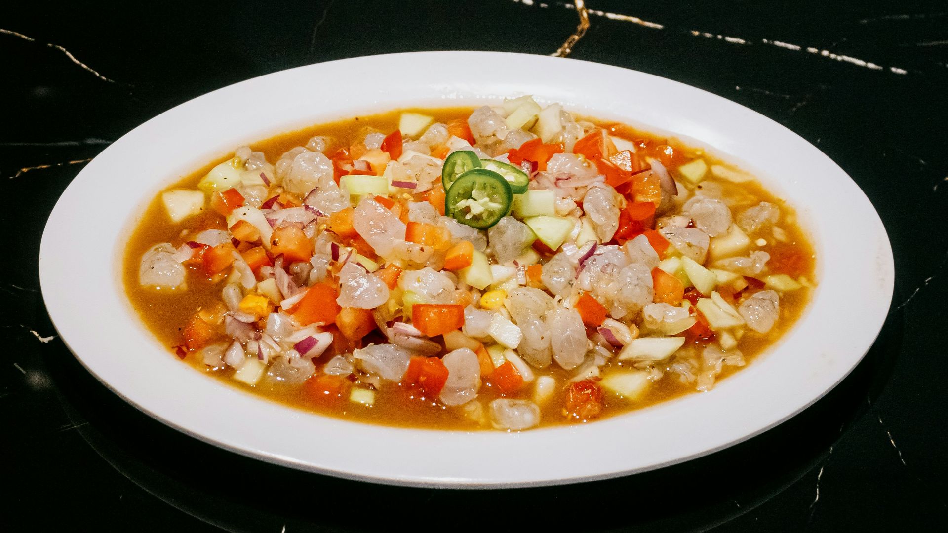 A white plate topped with a stew of vegetables