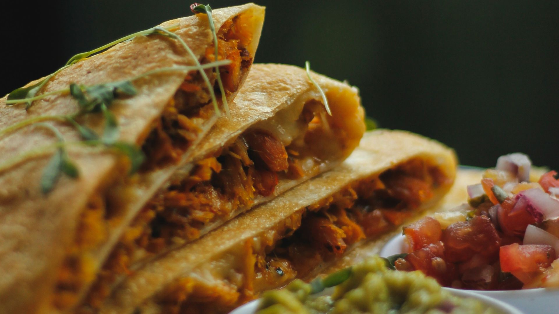 a plate topped with a quesadilla cut in half
