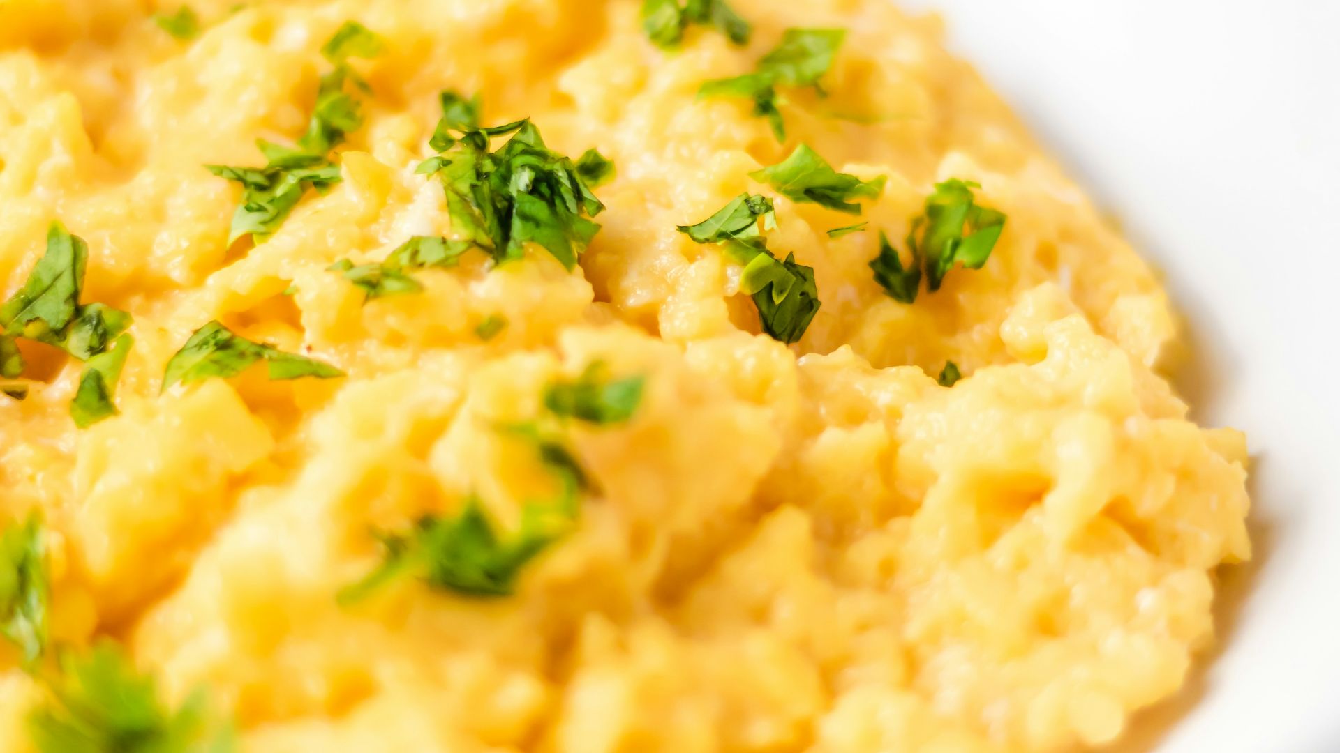 a bowl of mashed potatoes with parsley on top