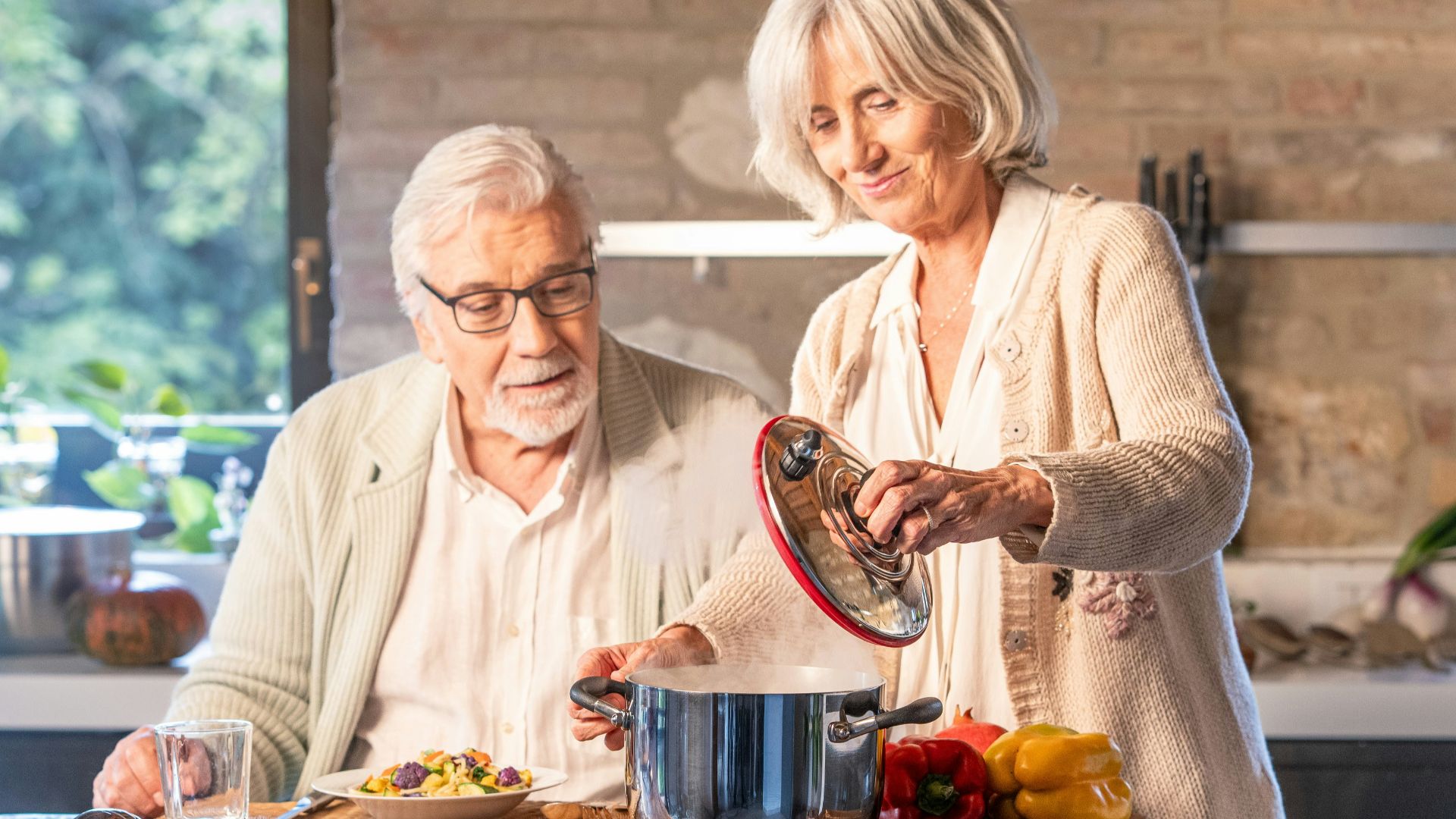 Elderly couple cooking together in a modern kitchen.