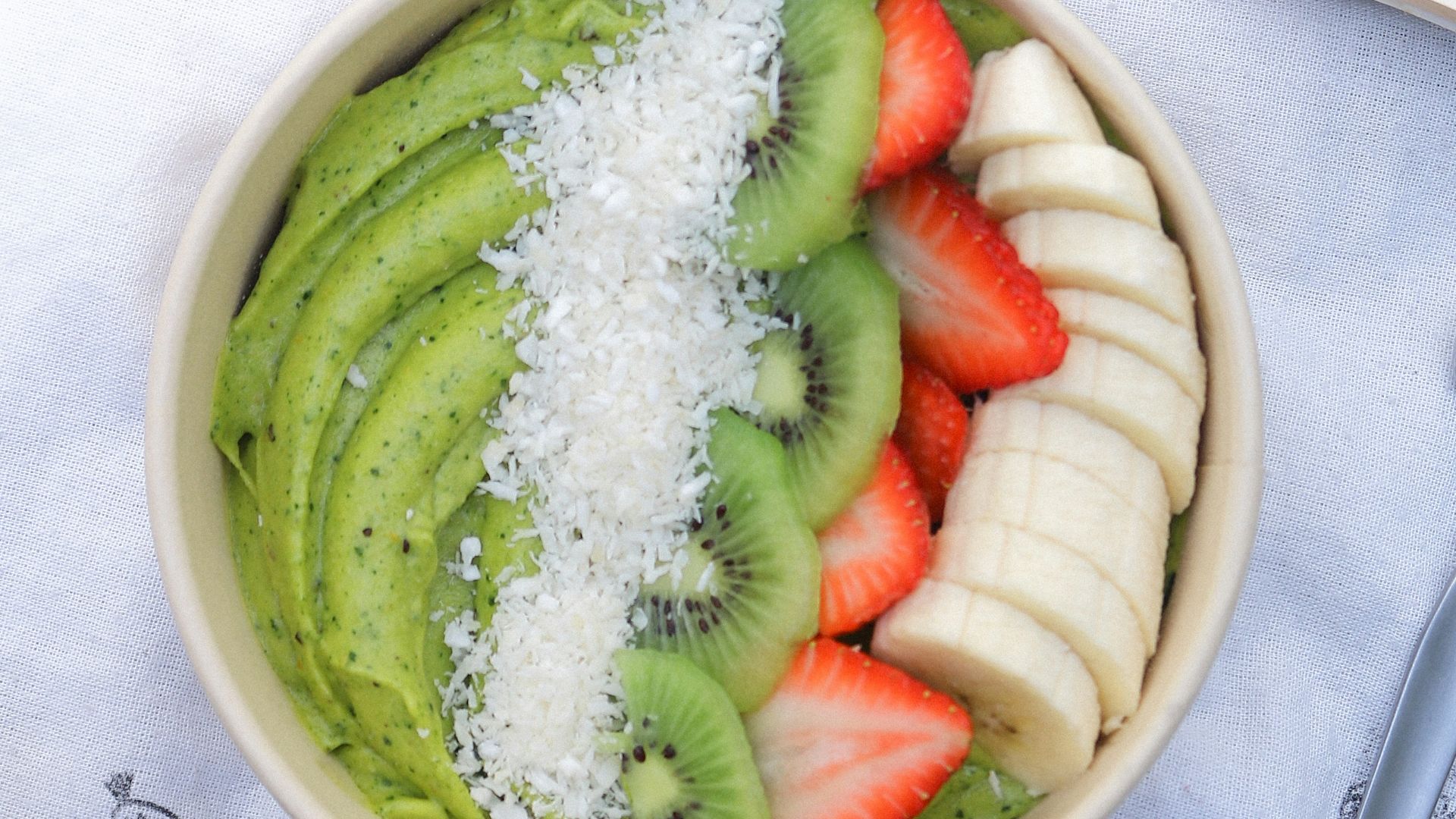 a bowl of fruit and a book on a table