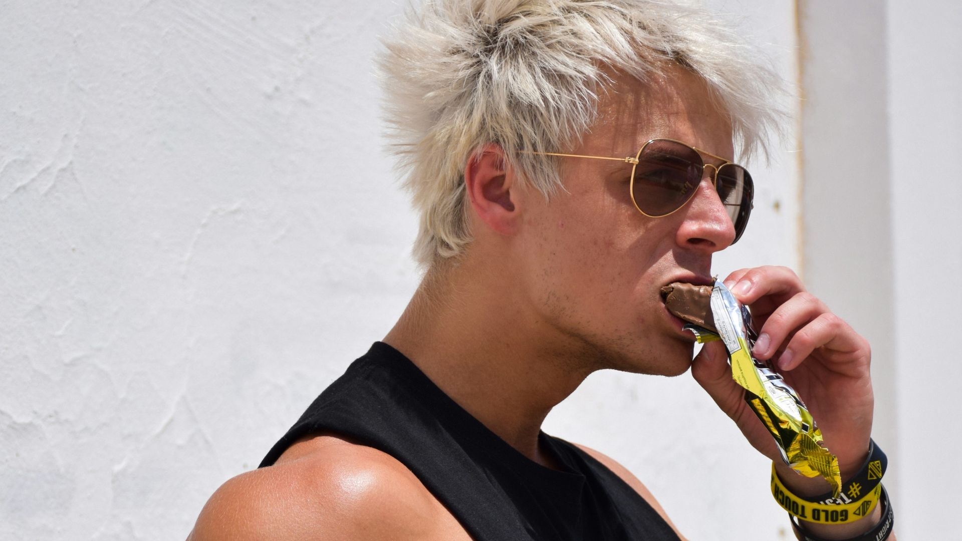 a man with white hair is drinking a drink