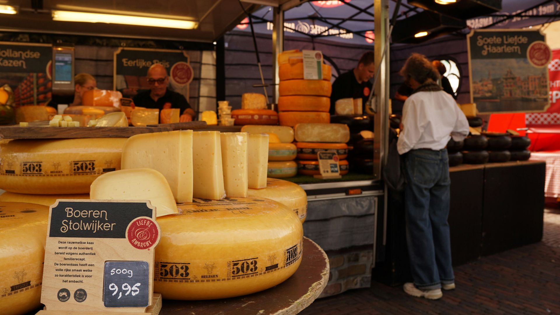 A cheese market with people buying delicious goods.