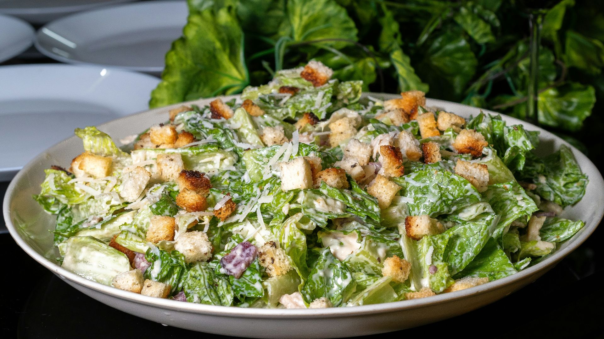 Delicious caesar salad is presented on a table.