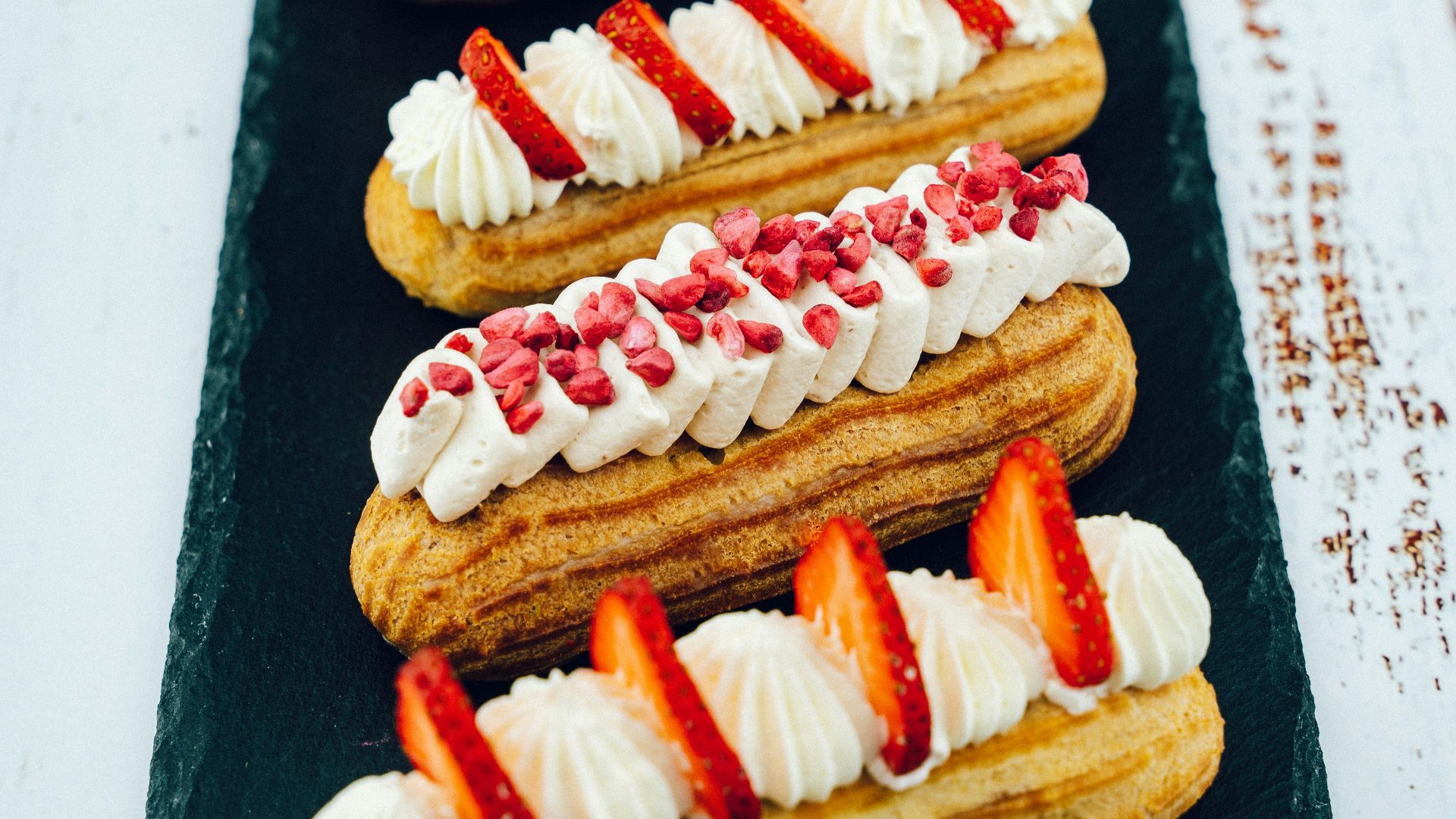 white and red pastry on black wooden table
