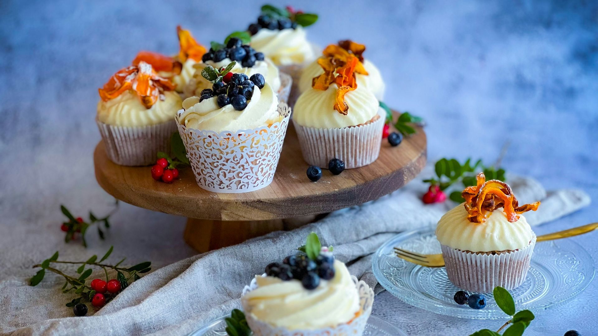 a plate of cupcakes with frosting and berries