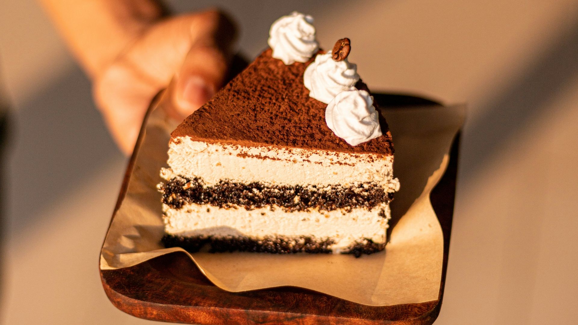 a person holding a piece of cake on a plate