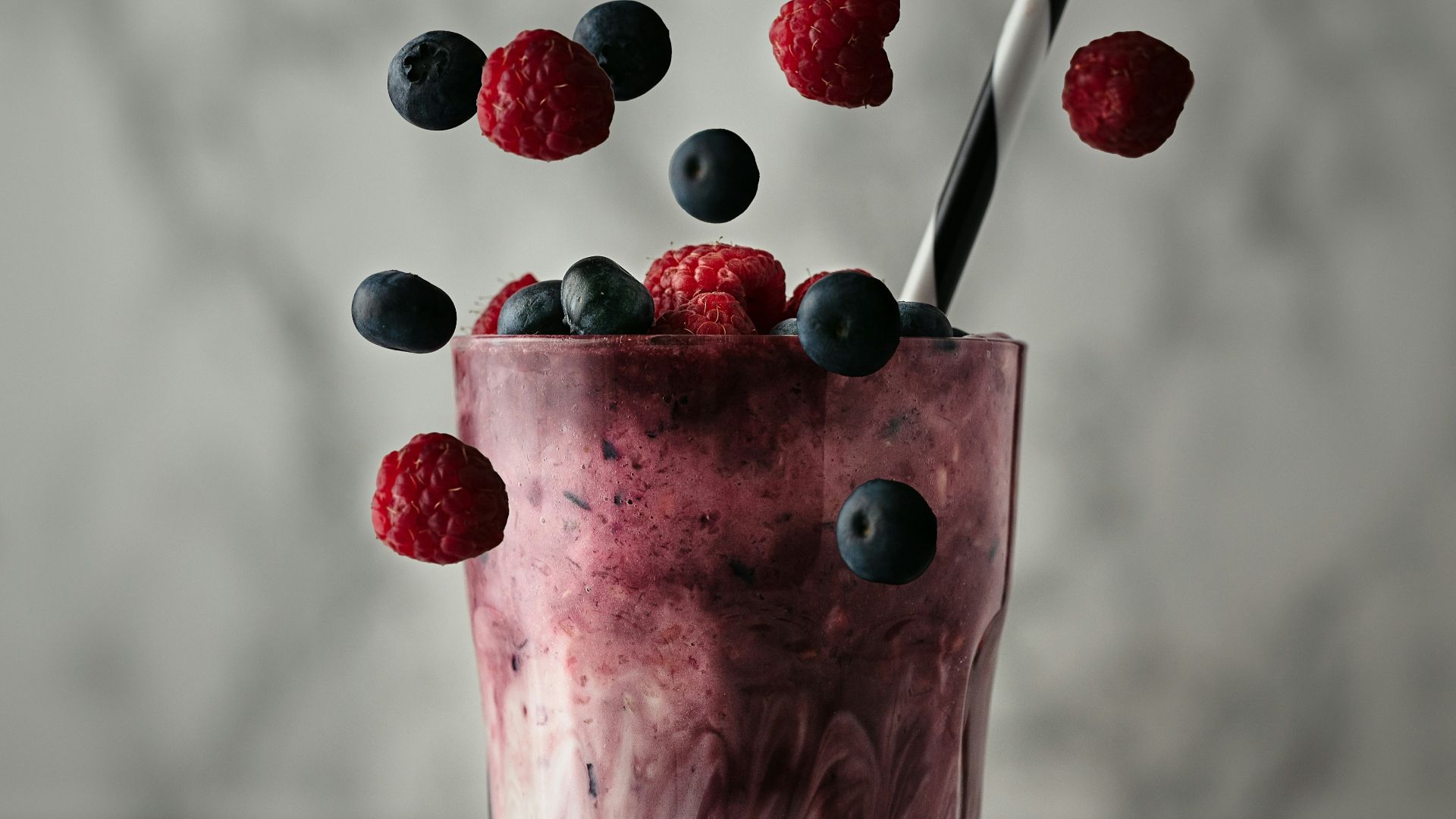 pink ice cream with red and blue berries on top