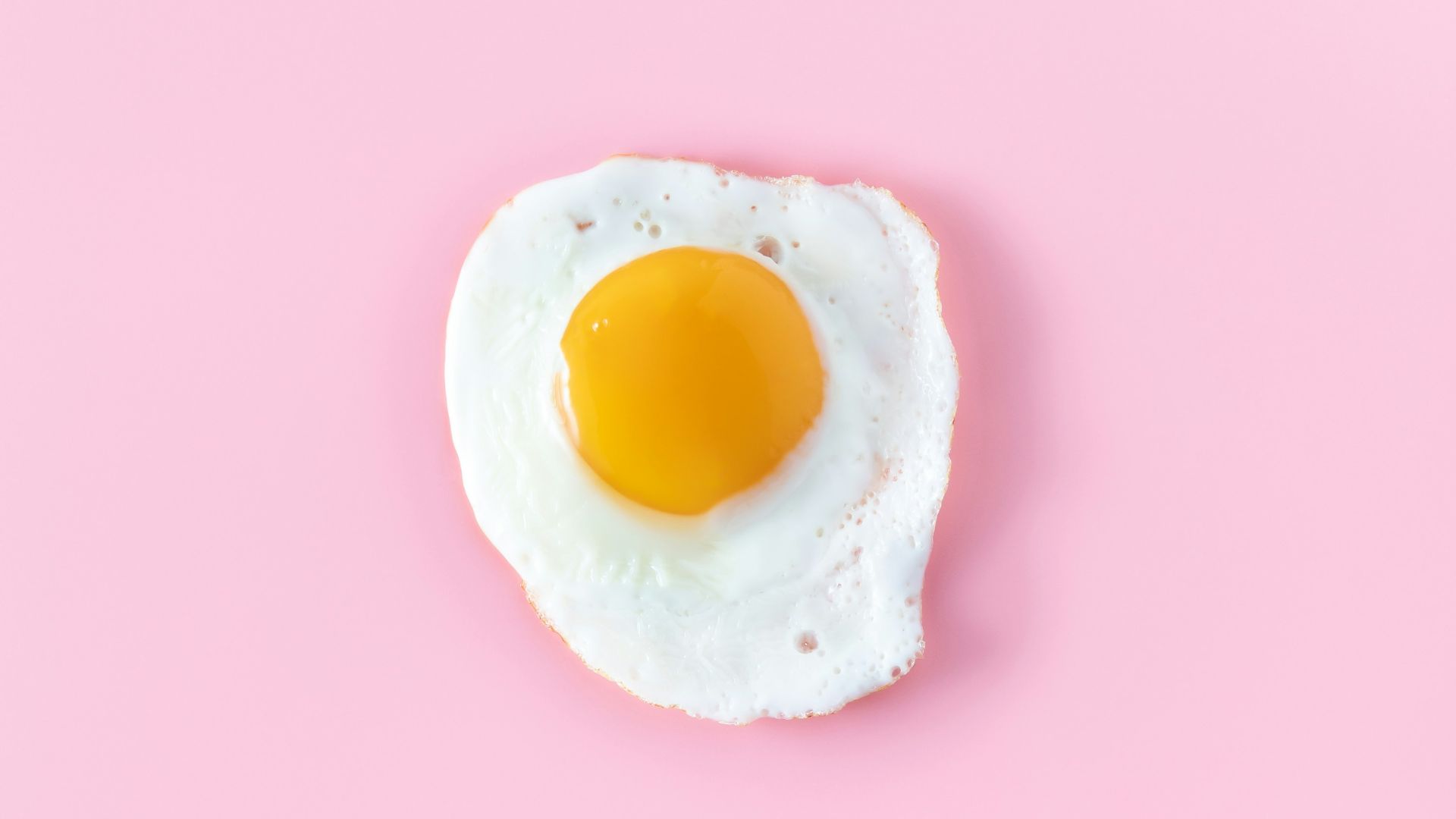 sunny side up egg on pink surface