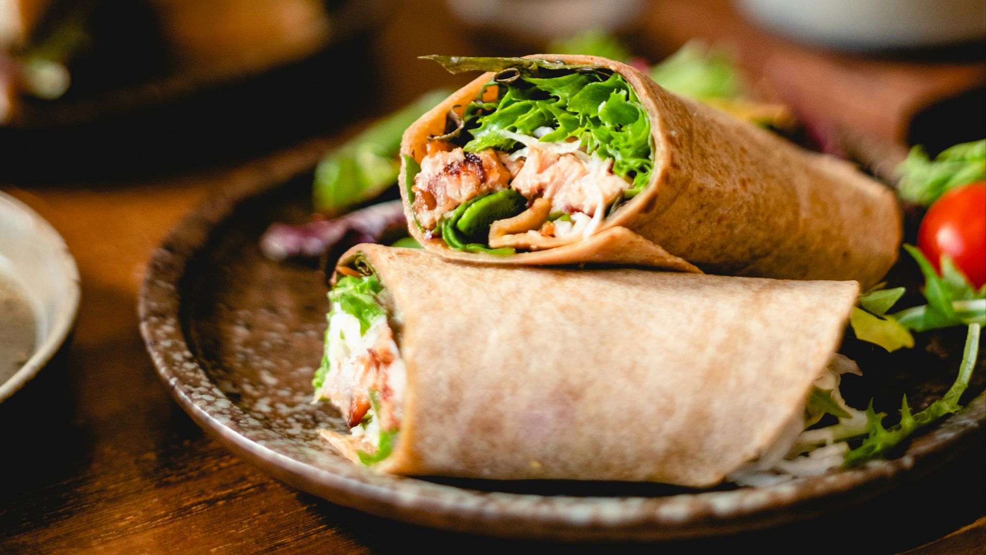 a plate with a burrito and salad on it