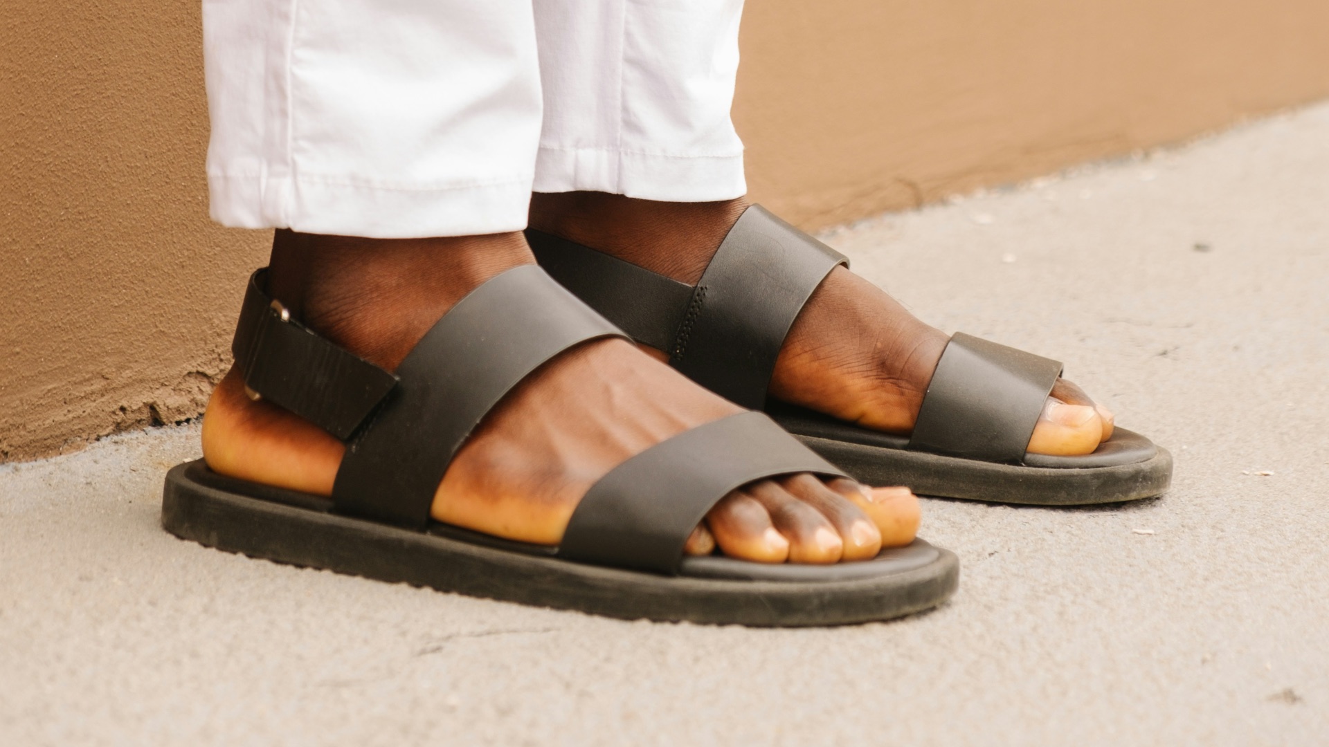 person wearing black leather sandals