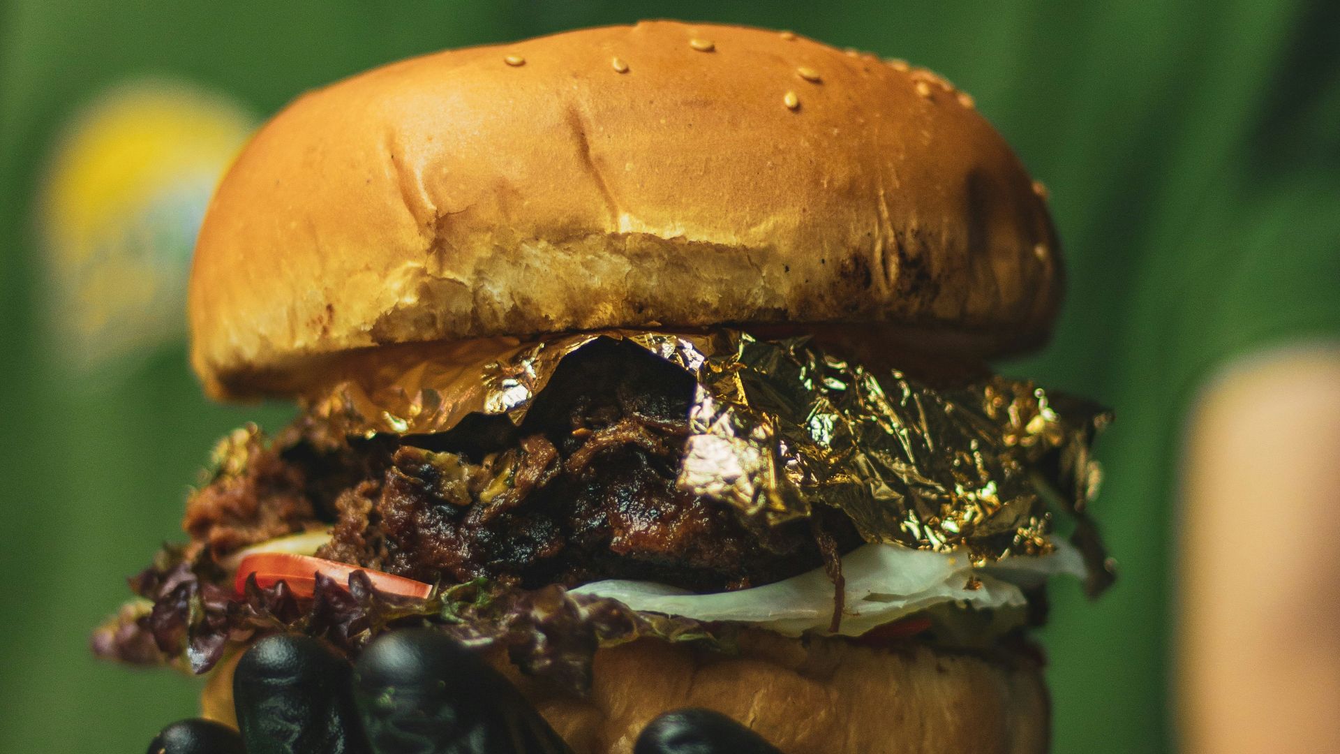 a person in a green shirt is holding a hamburger