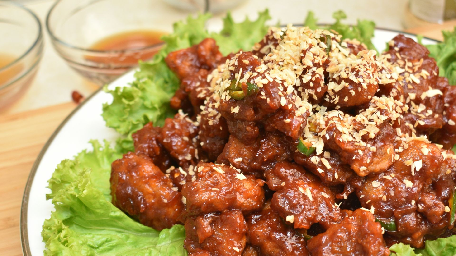 A white plate topped with lettuce covered in meat