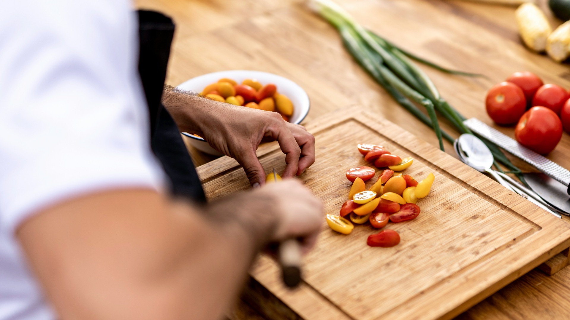 a person cutting up vegetables on a cutting board