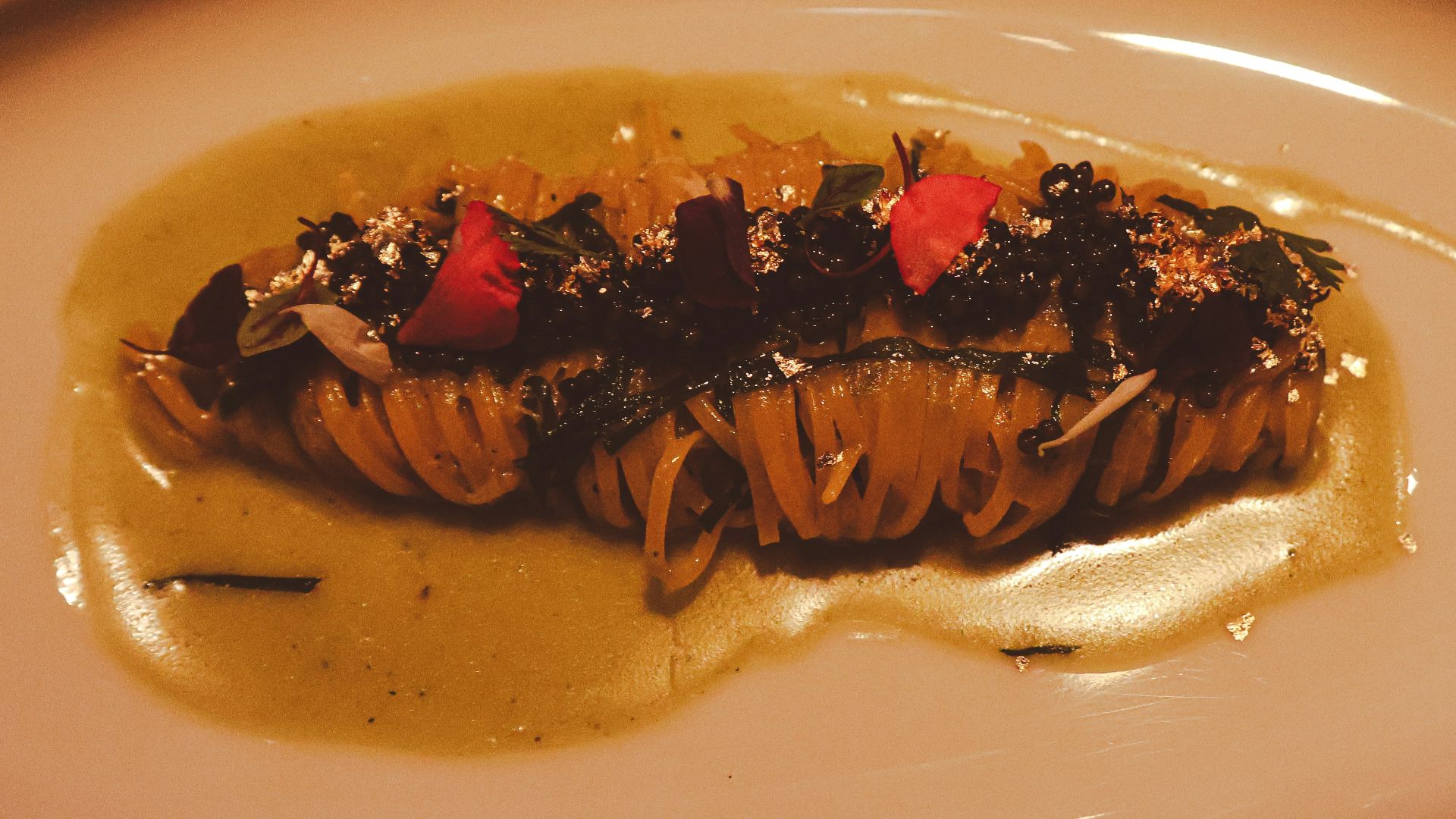 Pasta dish with sauce, herbs, and garnish.