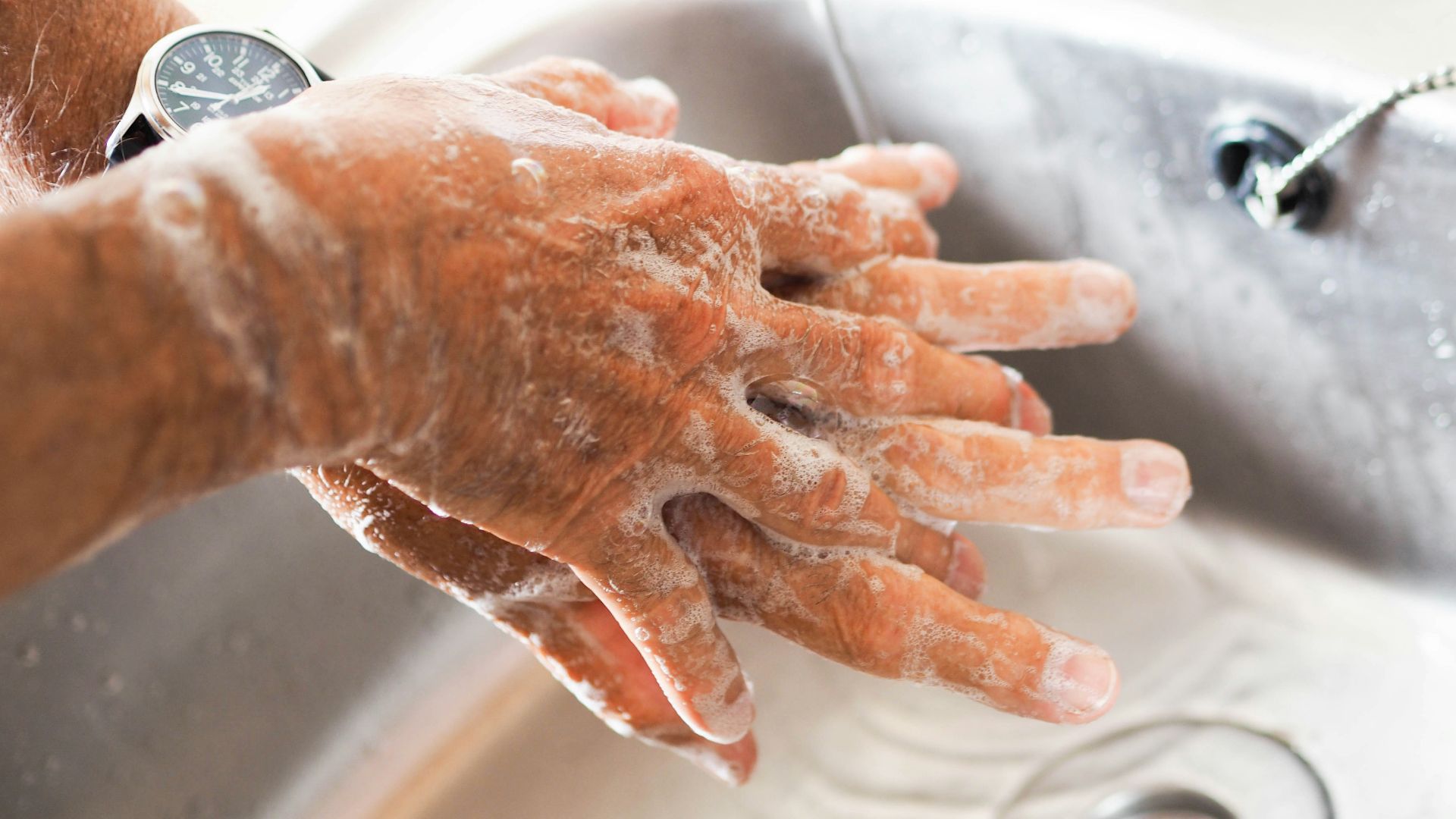 person washing hands on sink