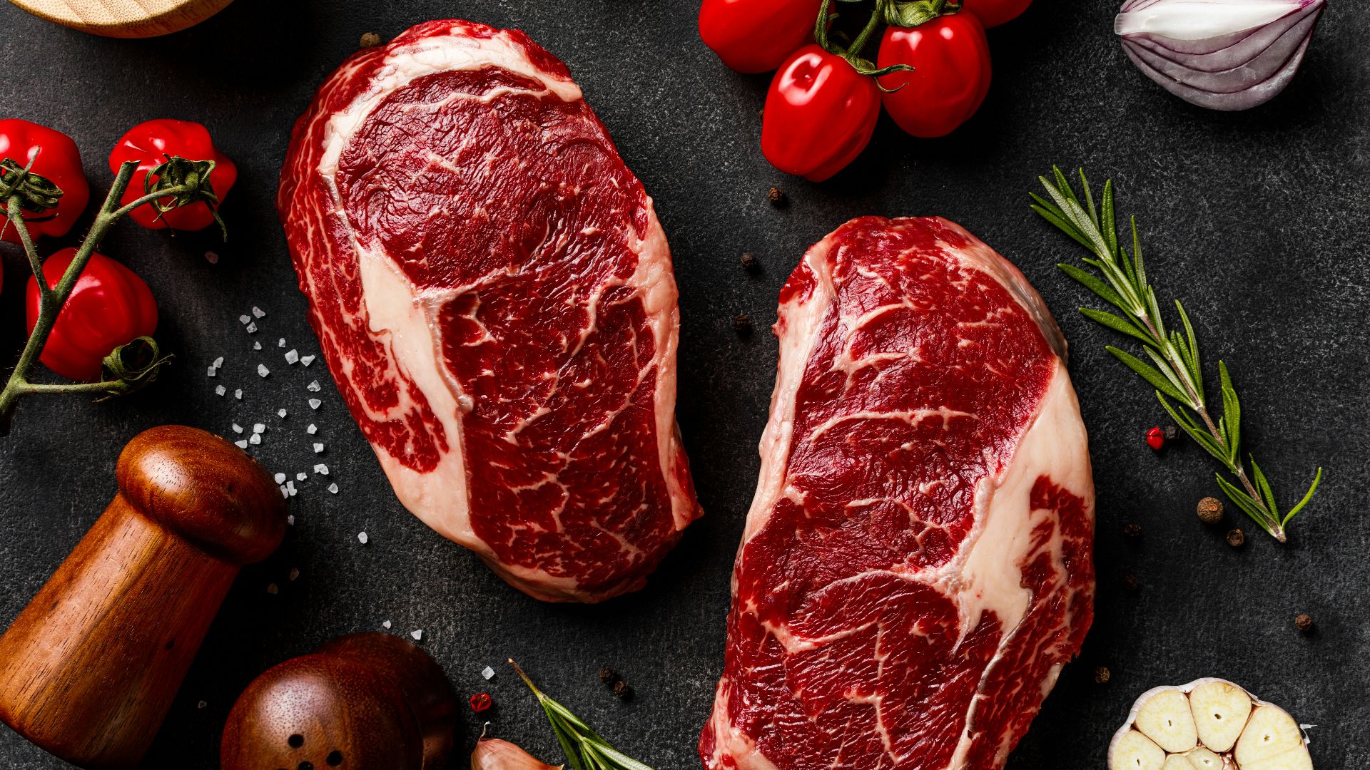 a couple of steaks sitting on top of a table