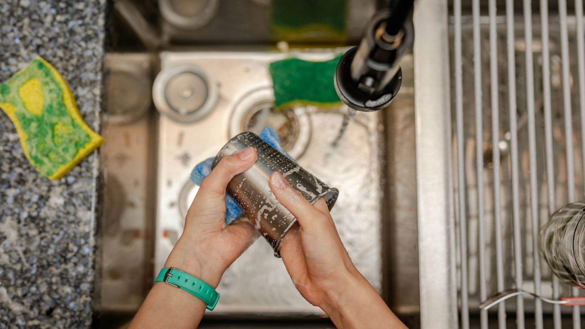 A person is cleaning a sink with a rag