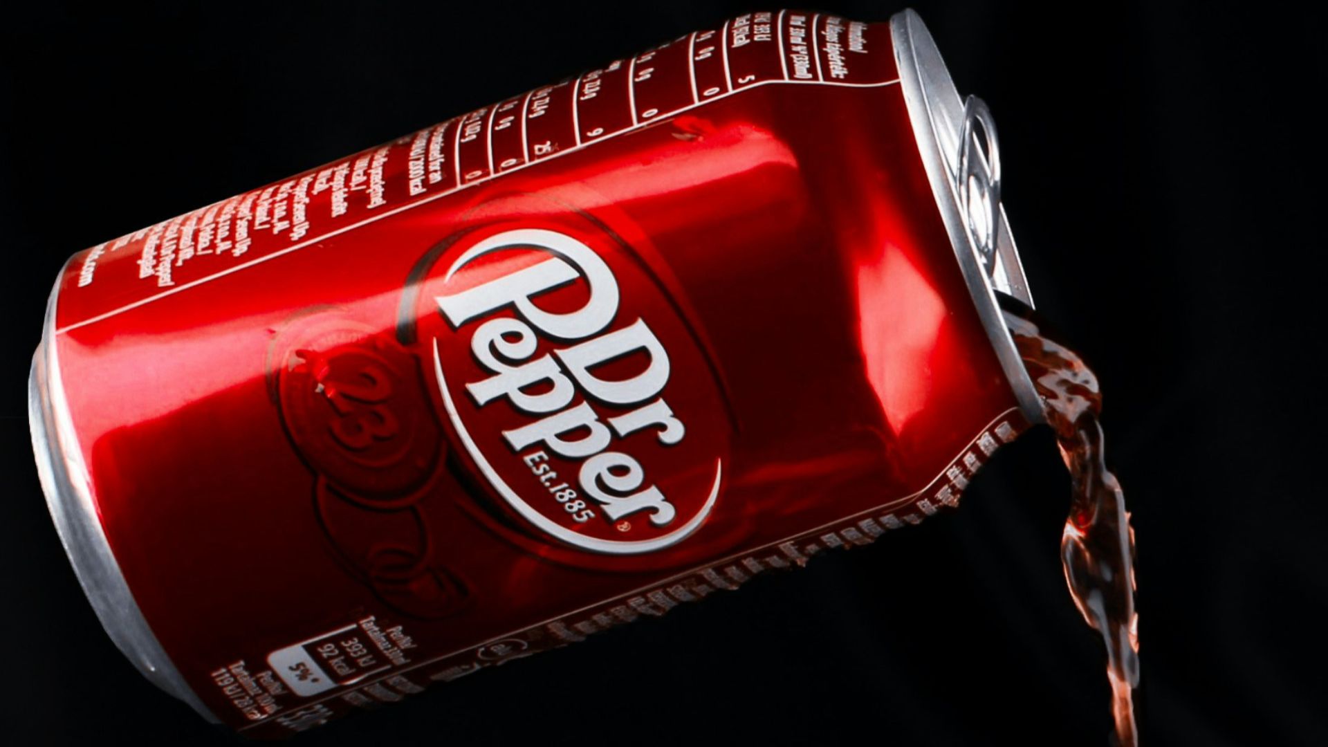 A can of coca cola being poured into a cup