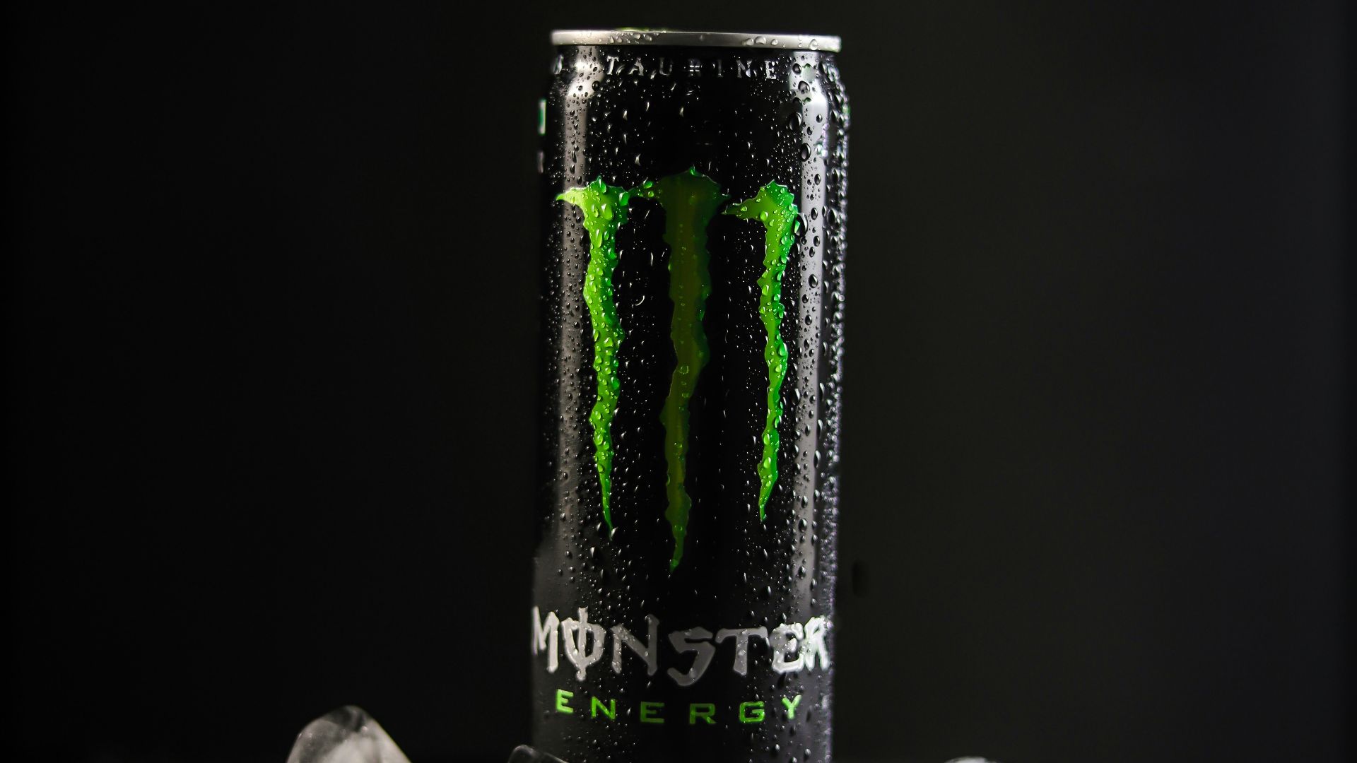 monster energy drink can on black and white textile