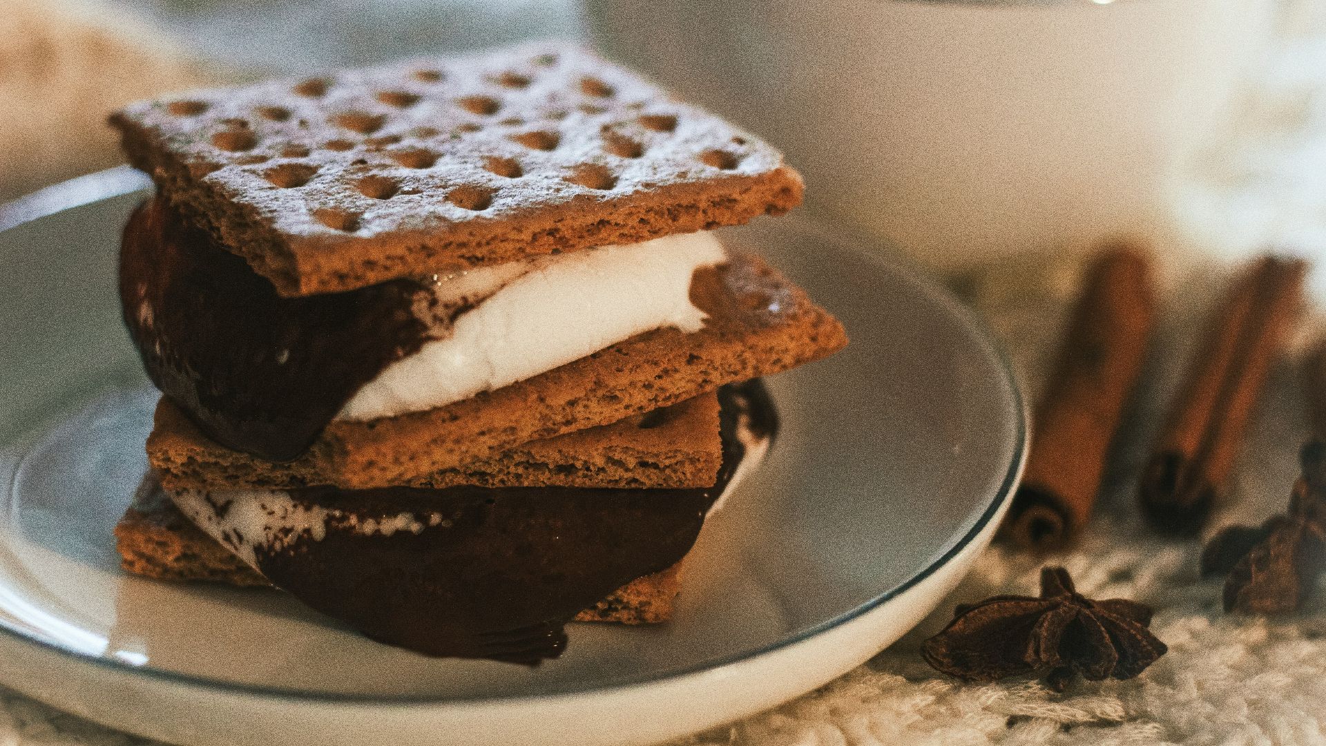a stack of waffle sandwiches on a plate next to a cup of coffee
