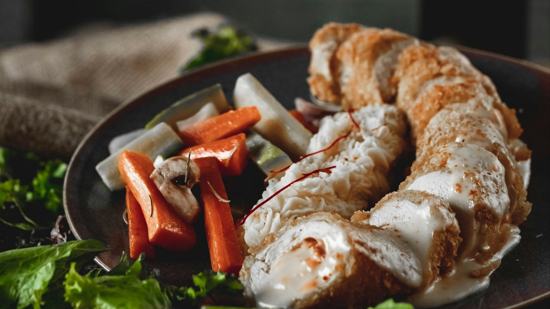 Rolled chicken with creamy sauce and vegetables