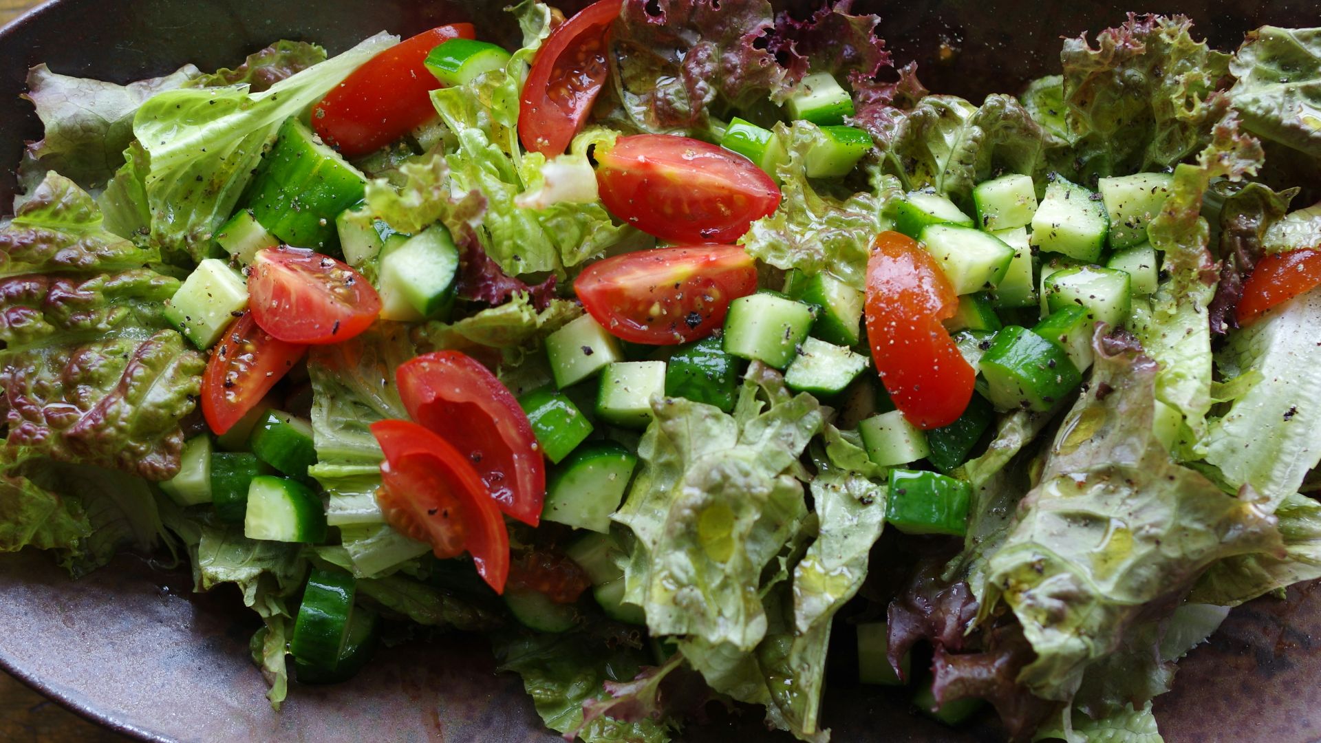 A bowl of salad on a wooden table