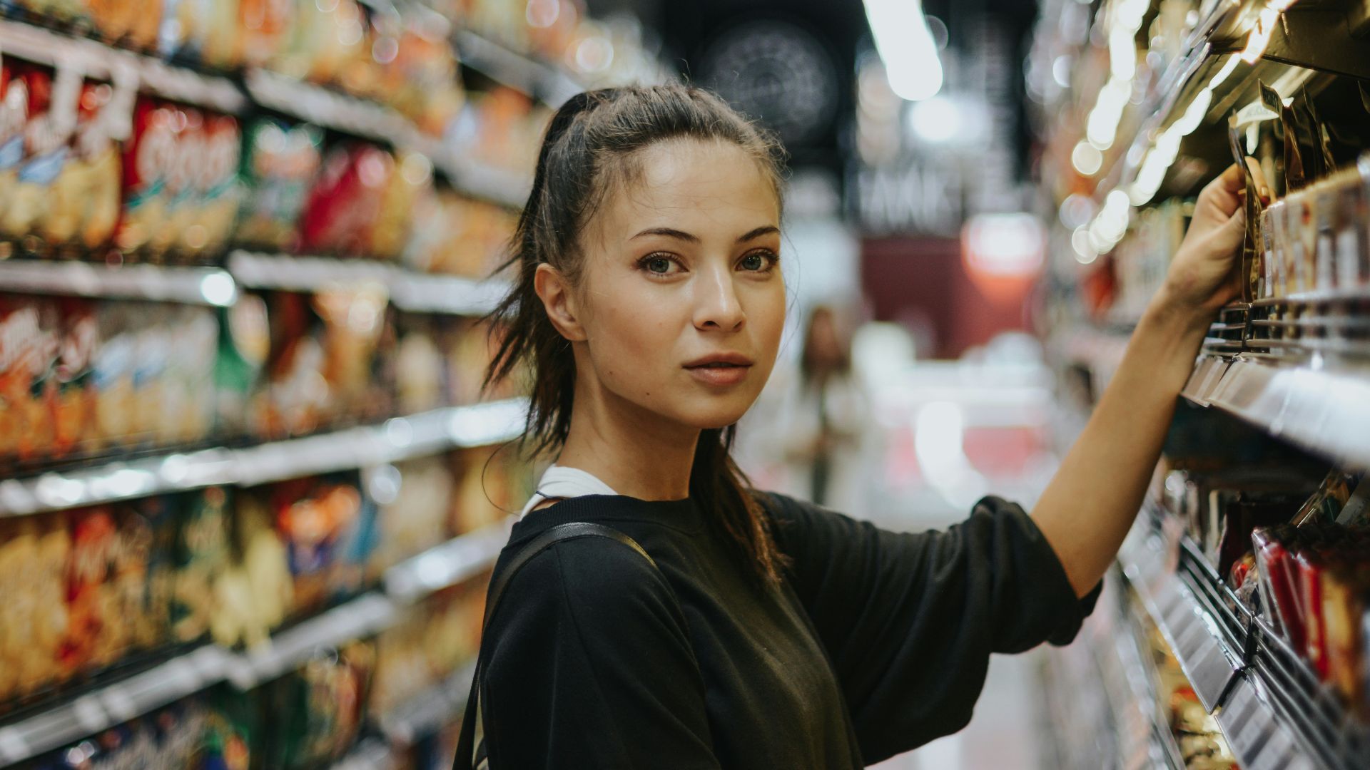 woman selecting packed food on gondola