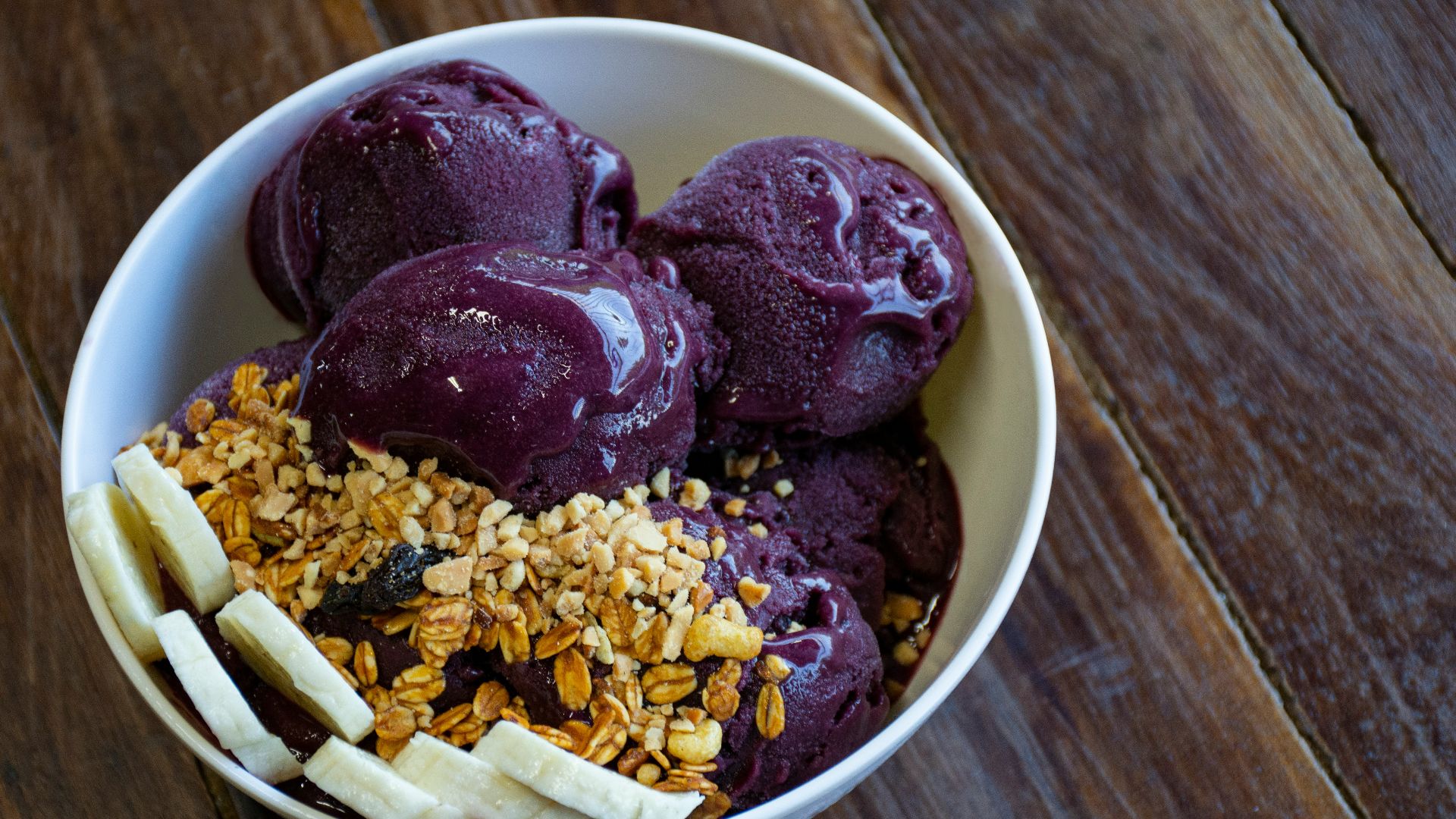 a bowl of ice cream with bananas and granola