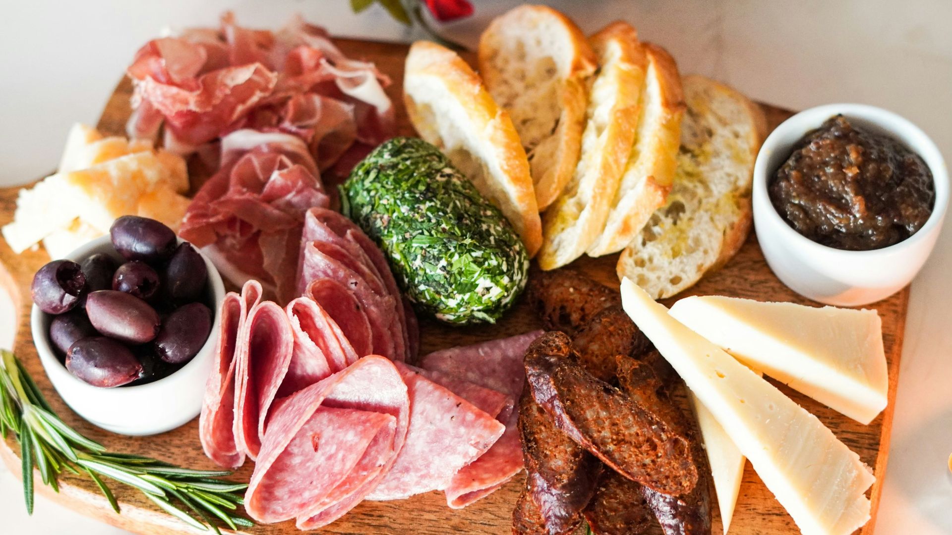 sliced meat with vegetable and bread on brown wooden chopping board