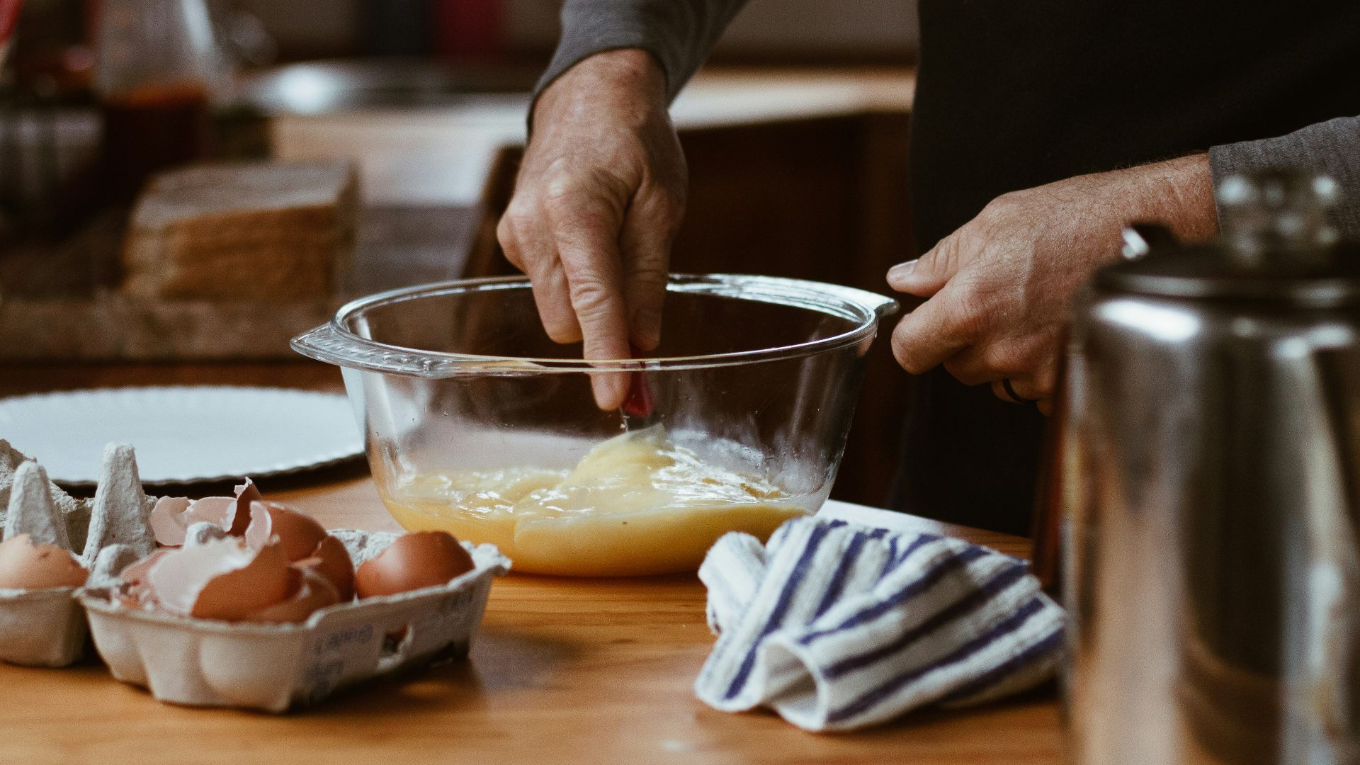person holding clear glass bowl with brown liquid