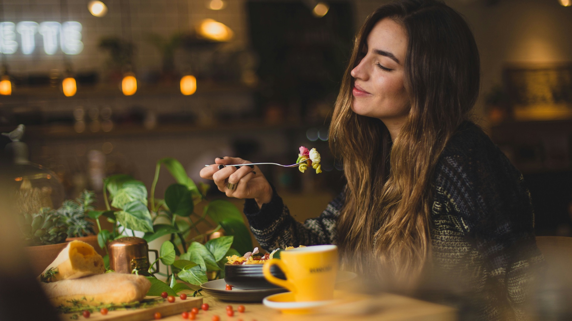 woman holding fork in front table