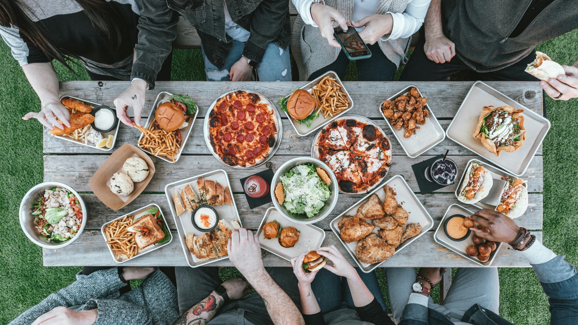 a group of people sitting around a table with food