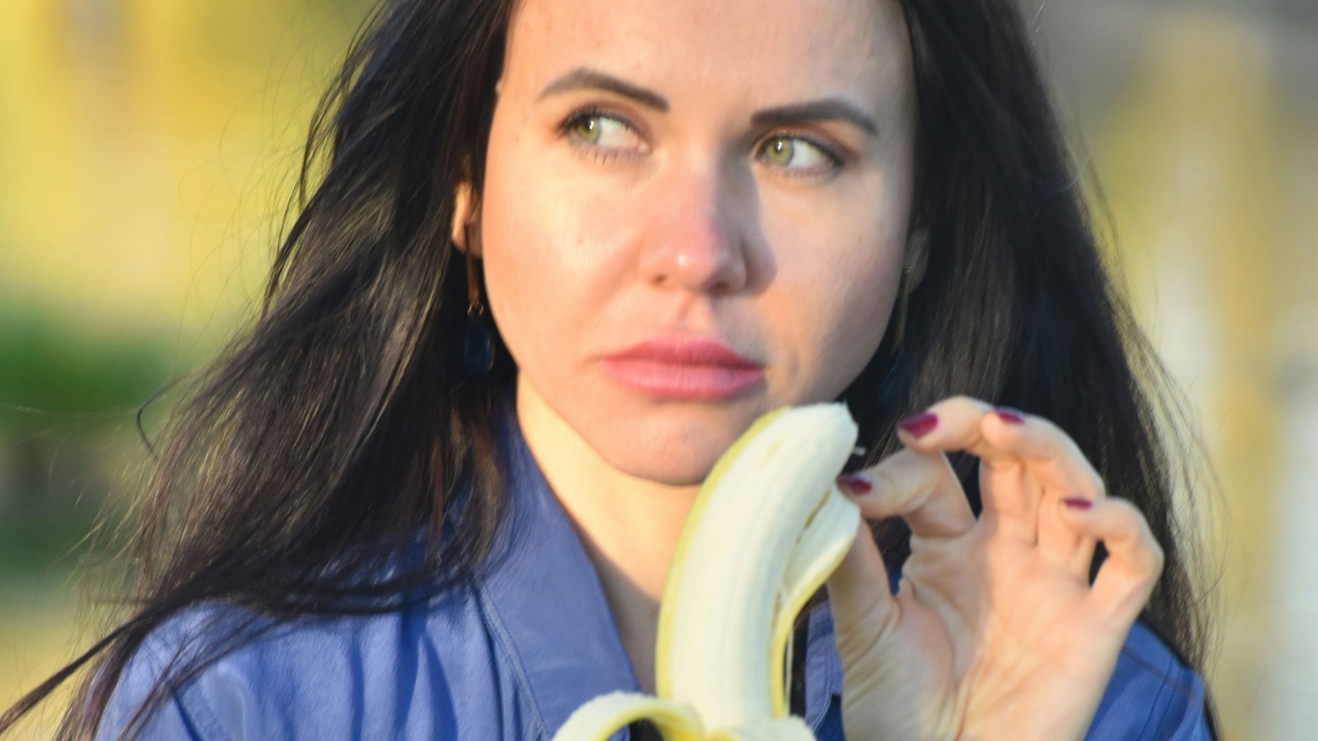 a woman holding a banana up to her face