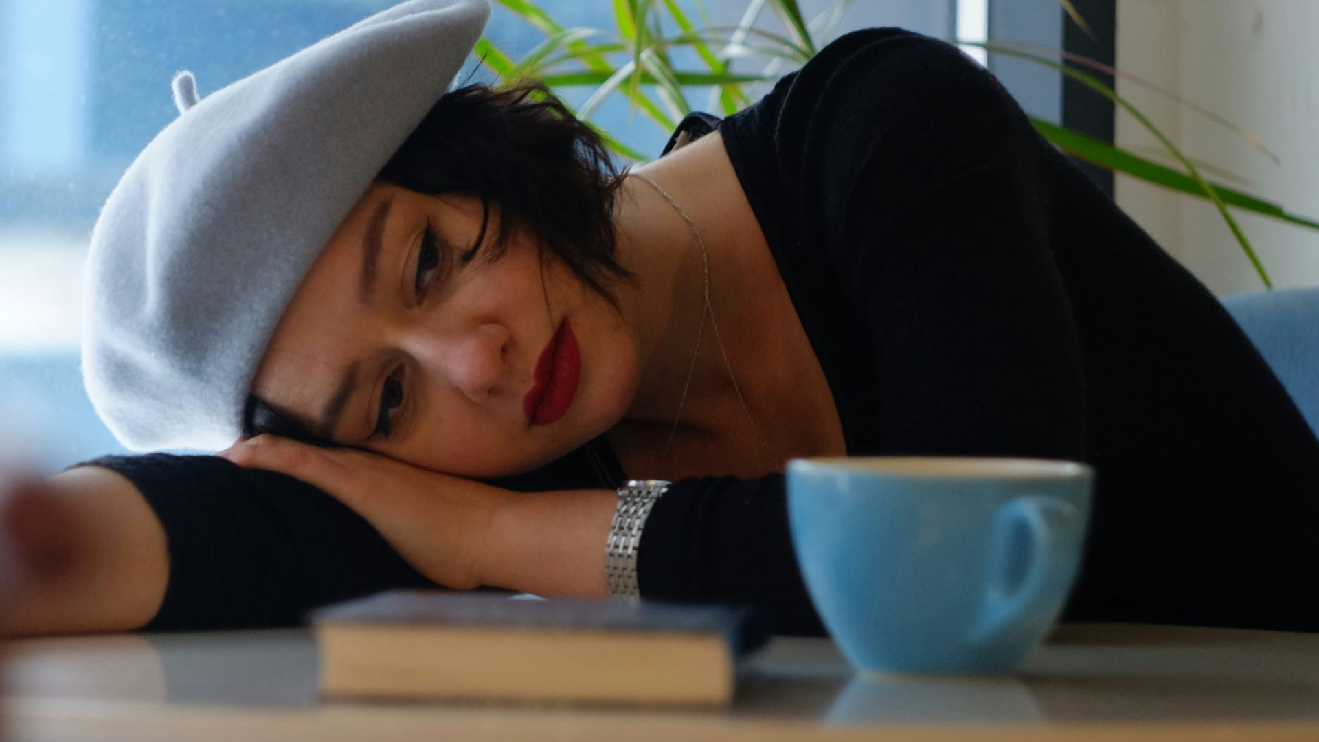 woman in black long sleeve shirt lying on white wooden table