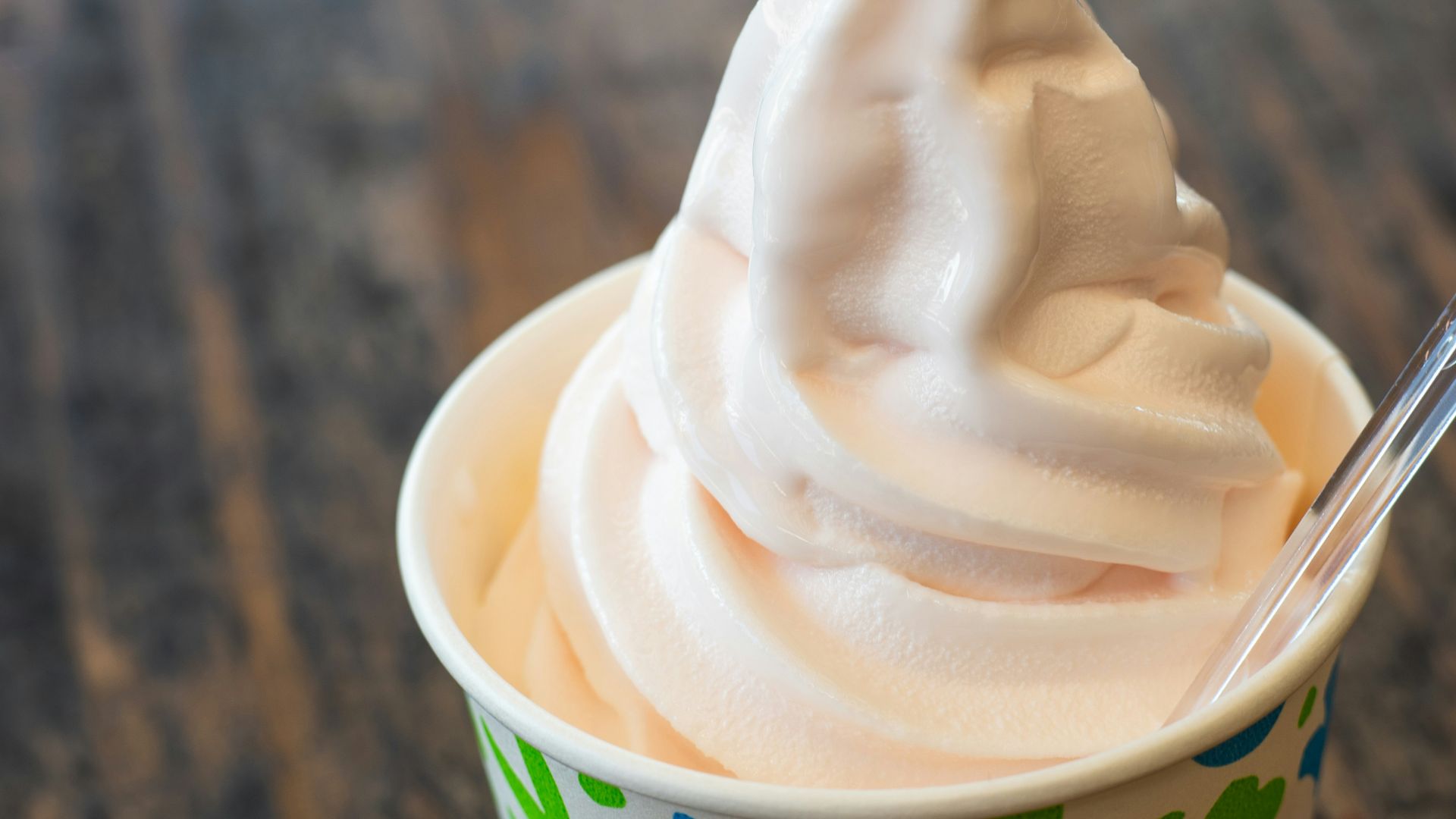 A cup filled with whipped cream on top of a wooden table