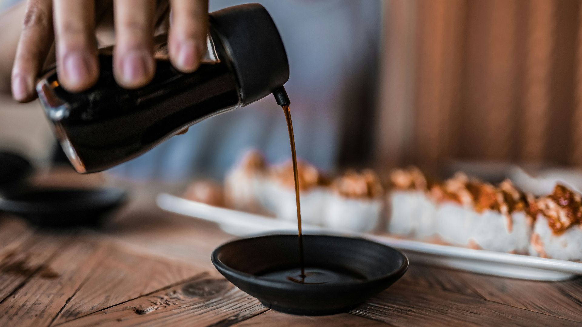 person pouring coffee on black ceramic mug