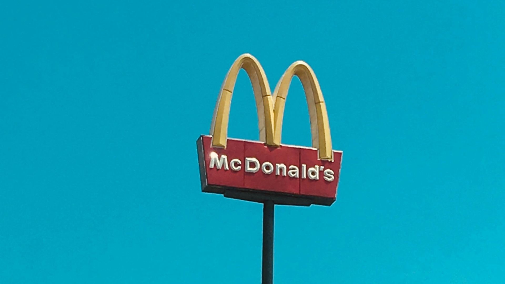 a mcdonald's restaurant sign in front of a blue sky