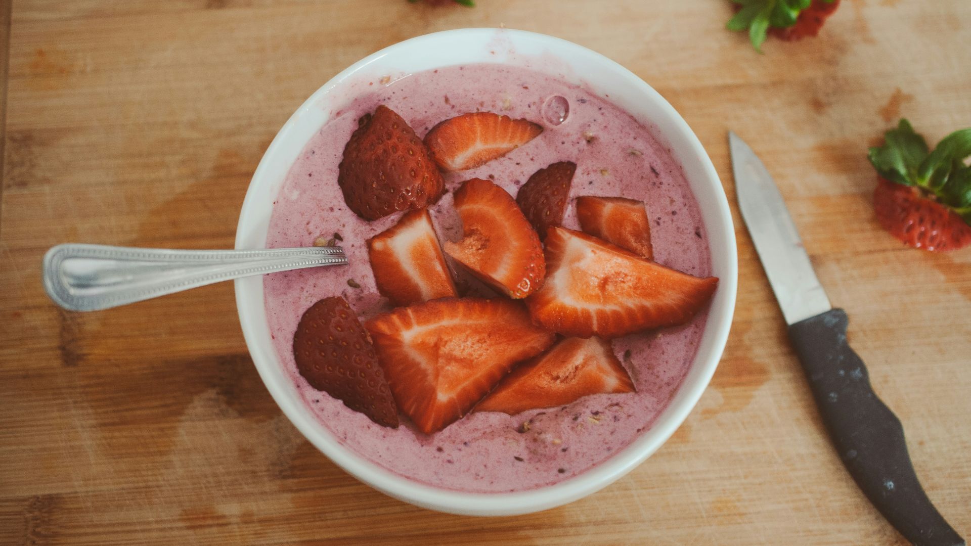 sliced strawberries in white ceramic bowl