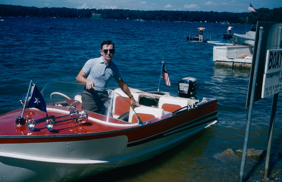 a man in a red and white boat in the water