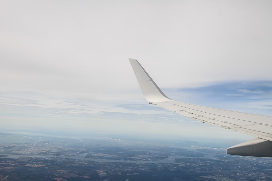 The wing of an airplane flying over a city