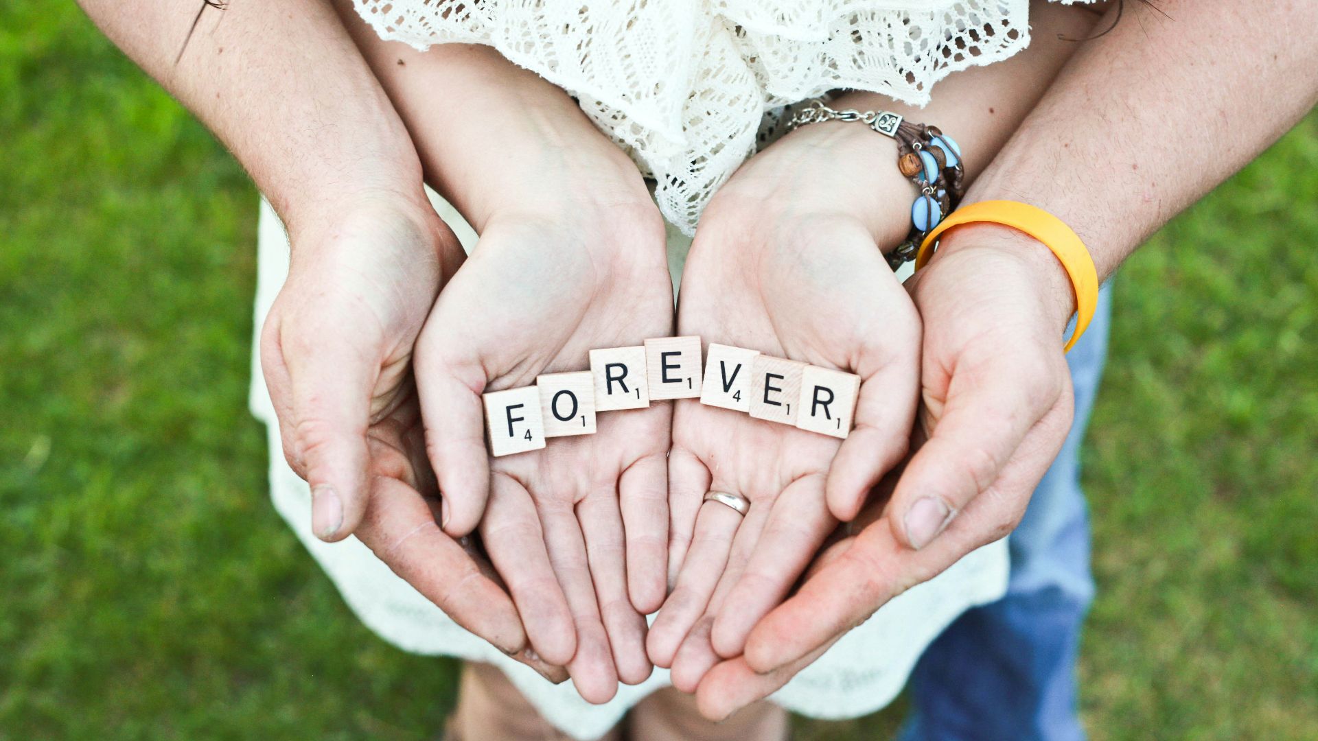adult and girl holding forever scrabble letters during daytime