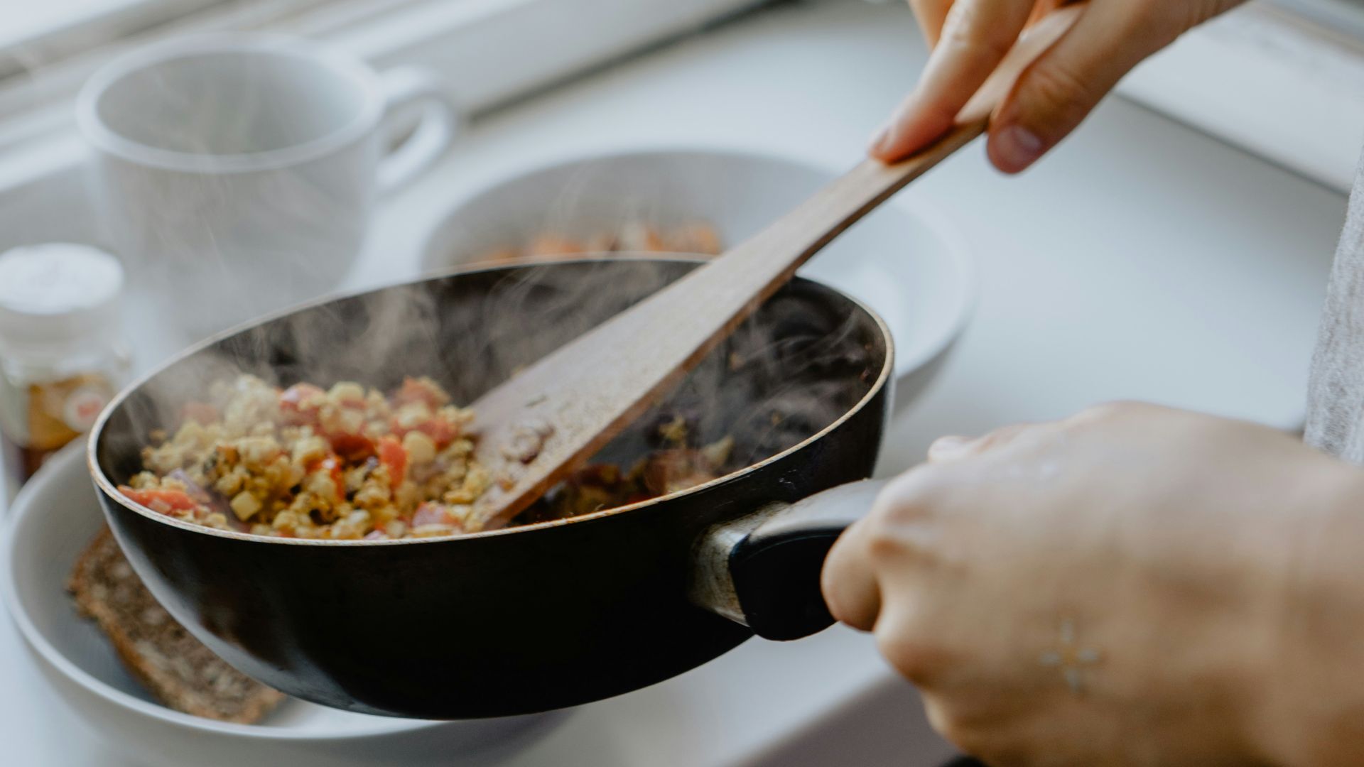 person holding black frying pan