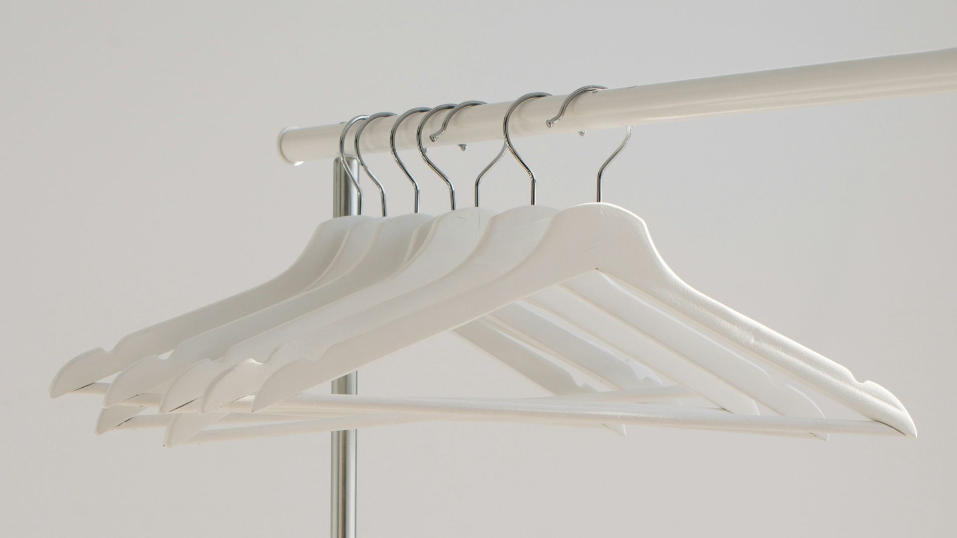 white clothes hangers hanging on rack