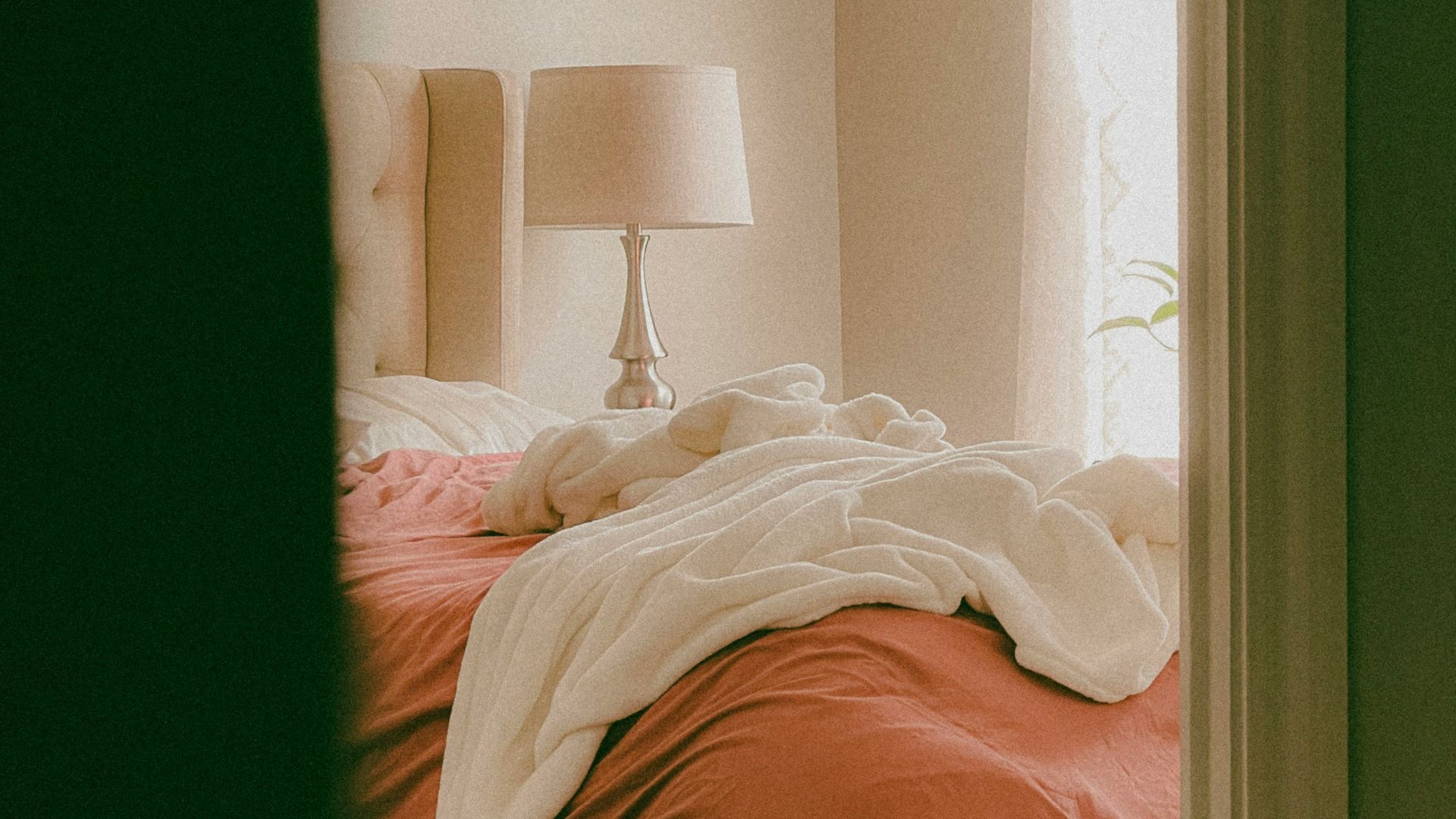 a bed sitting in a bedroom next to a window