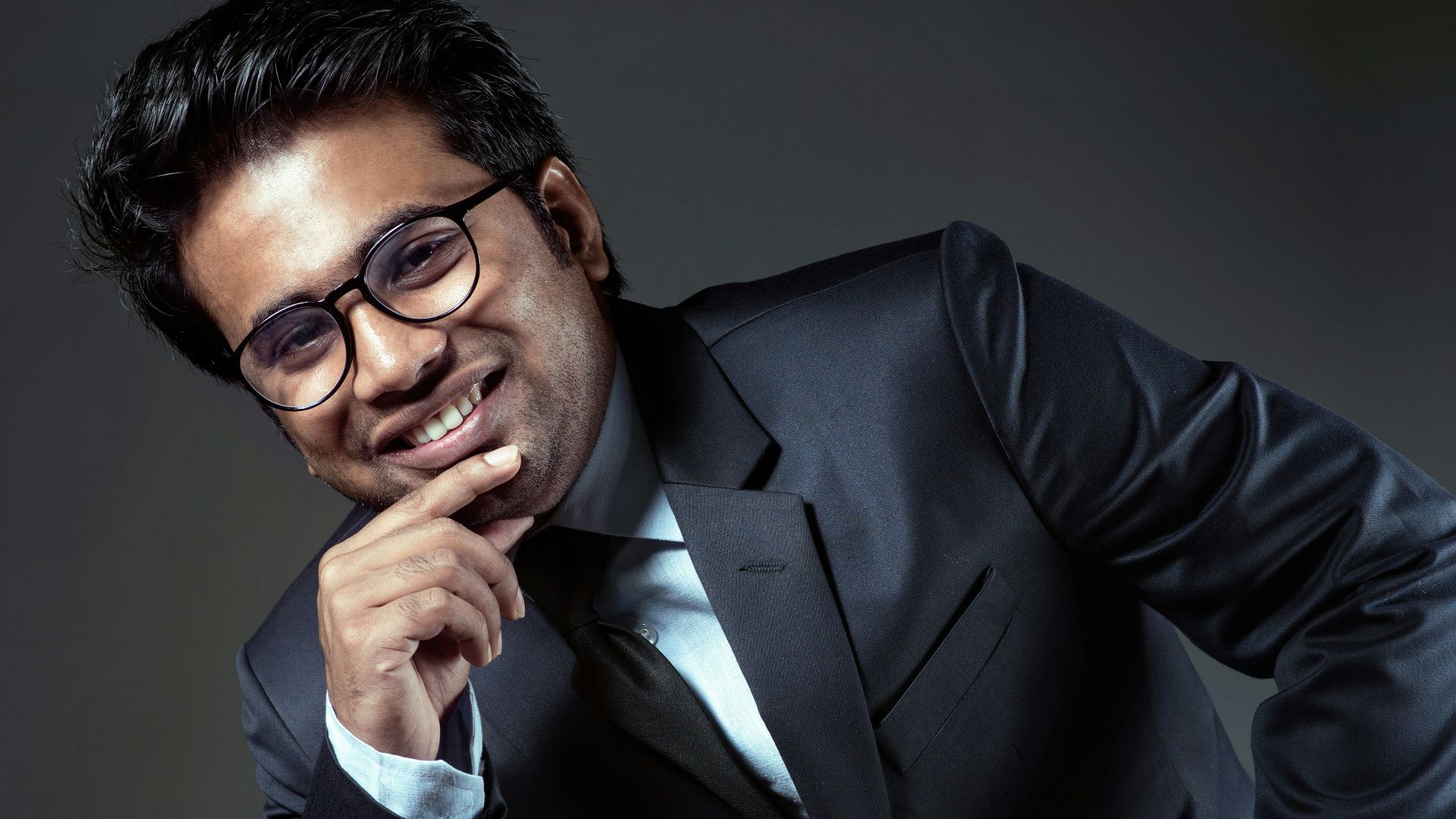 man in black suit jacket sitting on chair