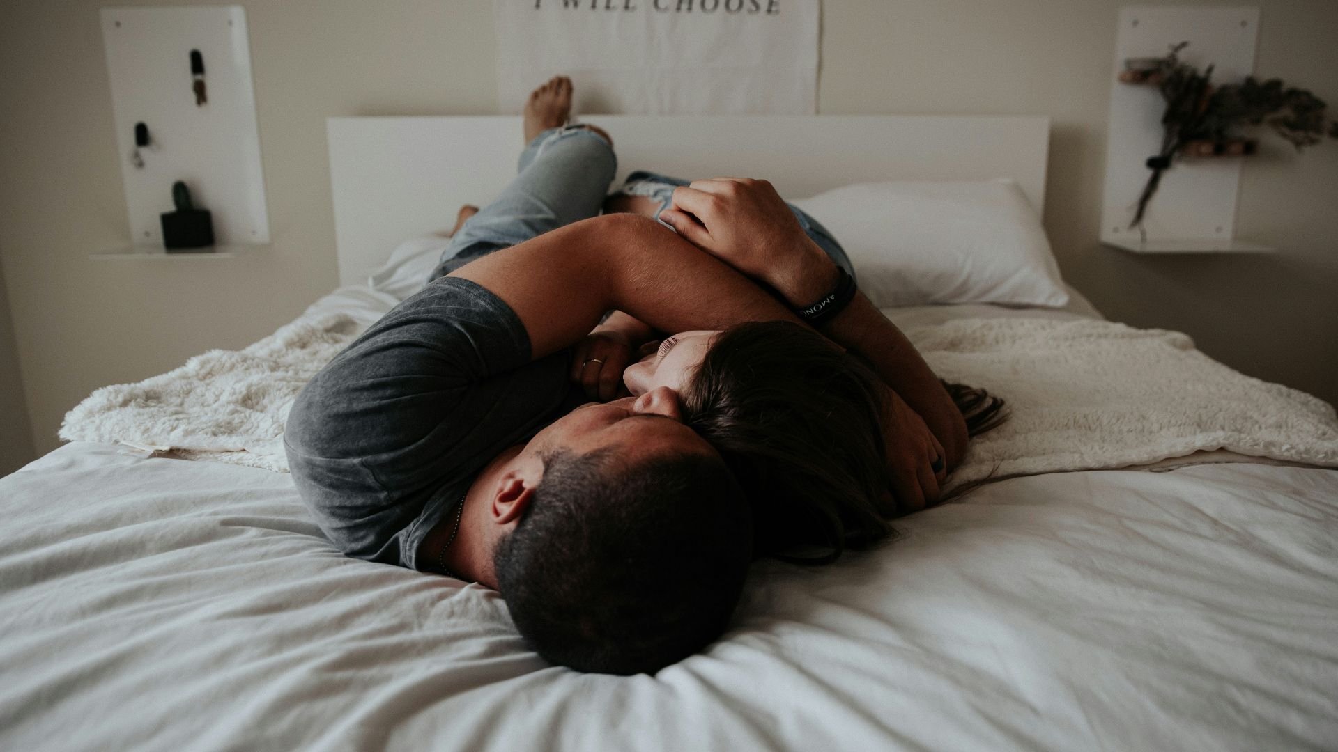 A man and woman cuddling together in bed.
